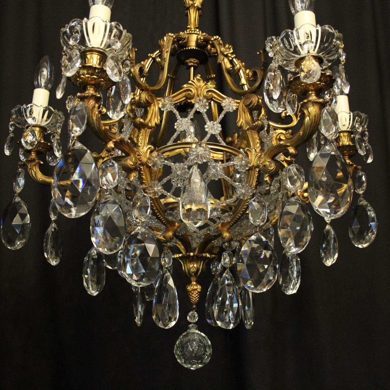 A French gilded bronze and crystal 7-light birdcage form antique chandelier, the 6 leaf scrolling arms with glass bobeche drip pans and bulbous candle sconces, issuing from a cage form interior decorated with a single inverted light fitting and