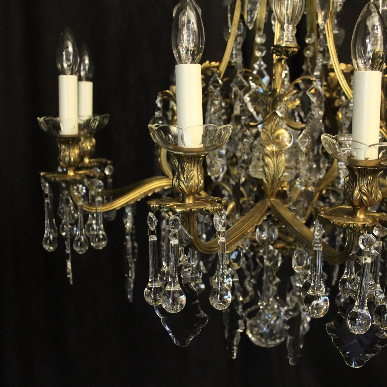 A French gilded bronze and crystal 11-light birdcage form antique chandelier, the 10 acanthus leaf reeded scrolling arms with foliated leaf bobeche glass drip pans and reeded bulbous candle sconces, issuing from a cage form interior with a large