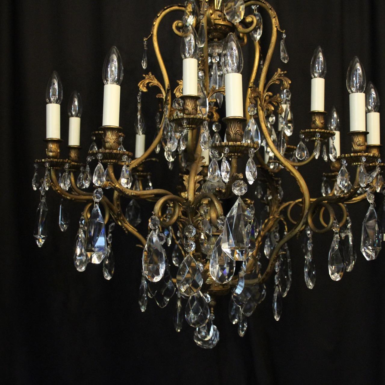 A French gilded bronze and crystal 16 light birdcage form antique chandelier, the fifteen reeded leaf clad scrolling arms with circular bobeche drip pans and bulbous candle sconces, issuing from a foliated cage form interior with a single inverted
