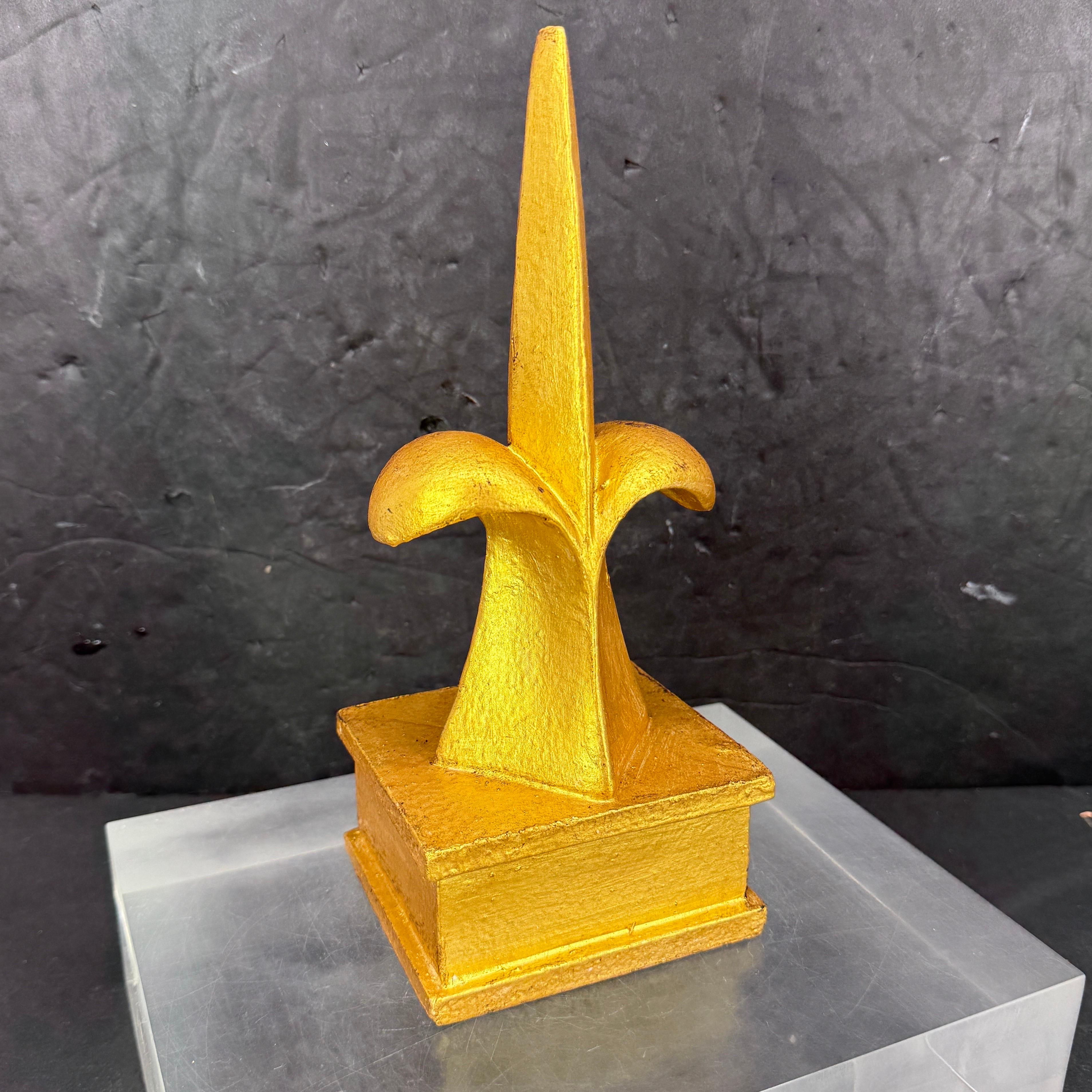 Scultura classica Fleur-de-Lis dorata. Il fleur-de-lis si basa sulla forma di un giglio. Tradizionalmente è stato utilizzato per rappresentare la regalità francese e in questo senso si dice che significhi perfezione, luce e vita. Questo frammento si