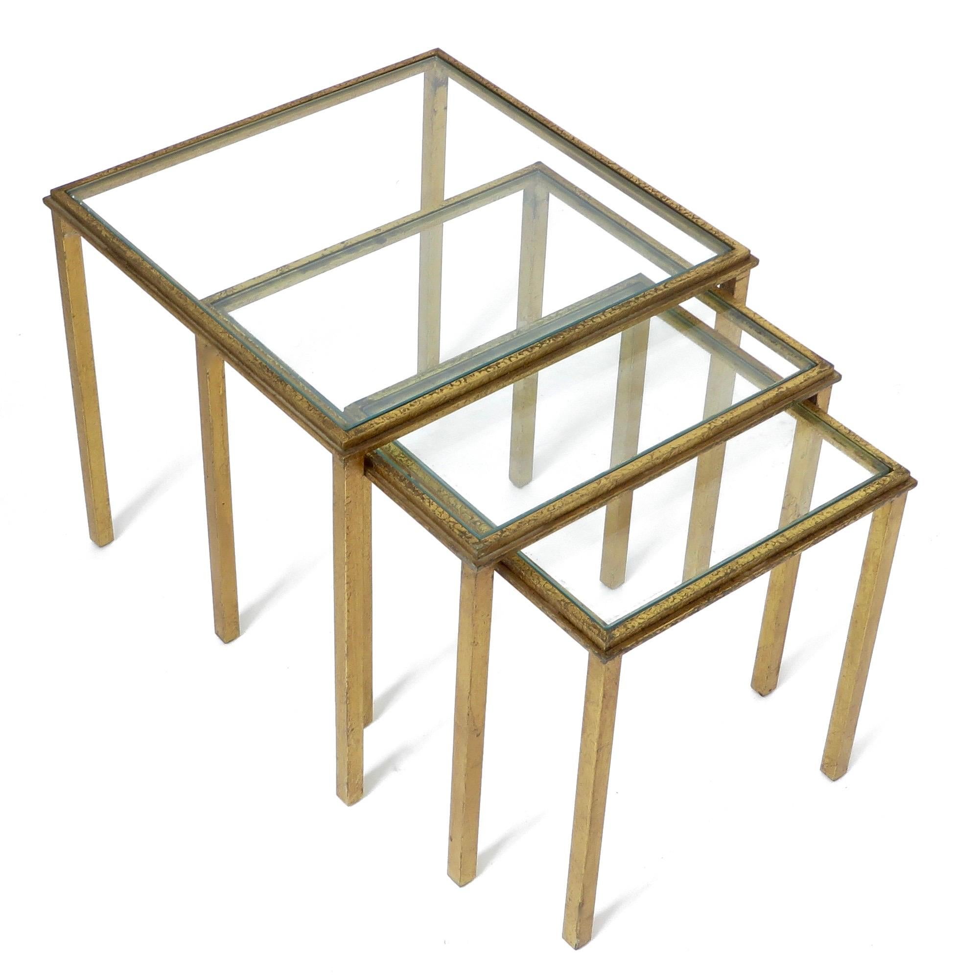 Ensemble de trois tables gigognes en fer doré, datant d'environ 1960 et créées par un designer français. 
Roger Thibier.
Estampillé Roger Thibier.
Le plus grand : 15