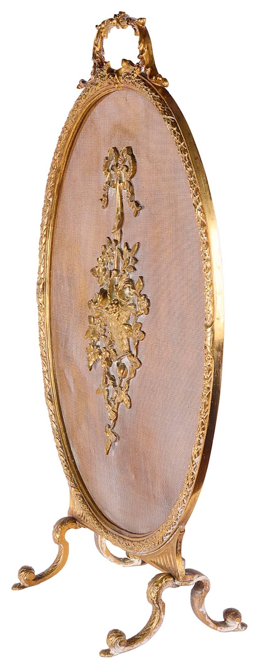 A good quality late 19th century French ormolu oval fire screen. Having a scrolling carrying handle to the top, a central ormolu basket of flowers and raised on scaled out swept feet.
