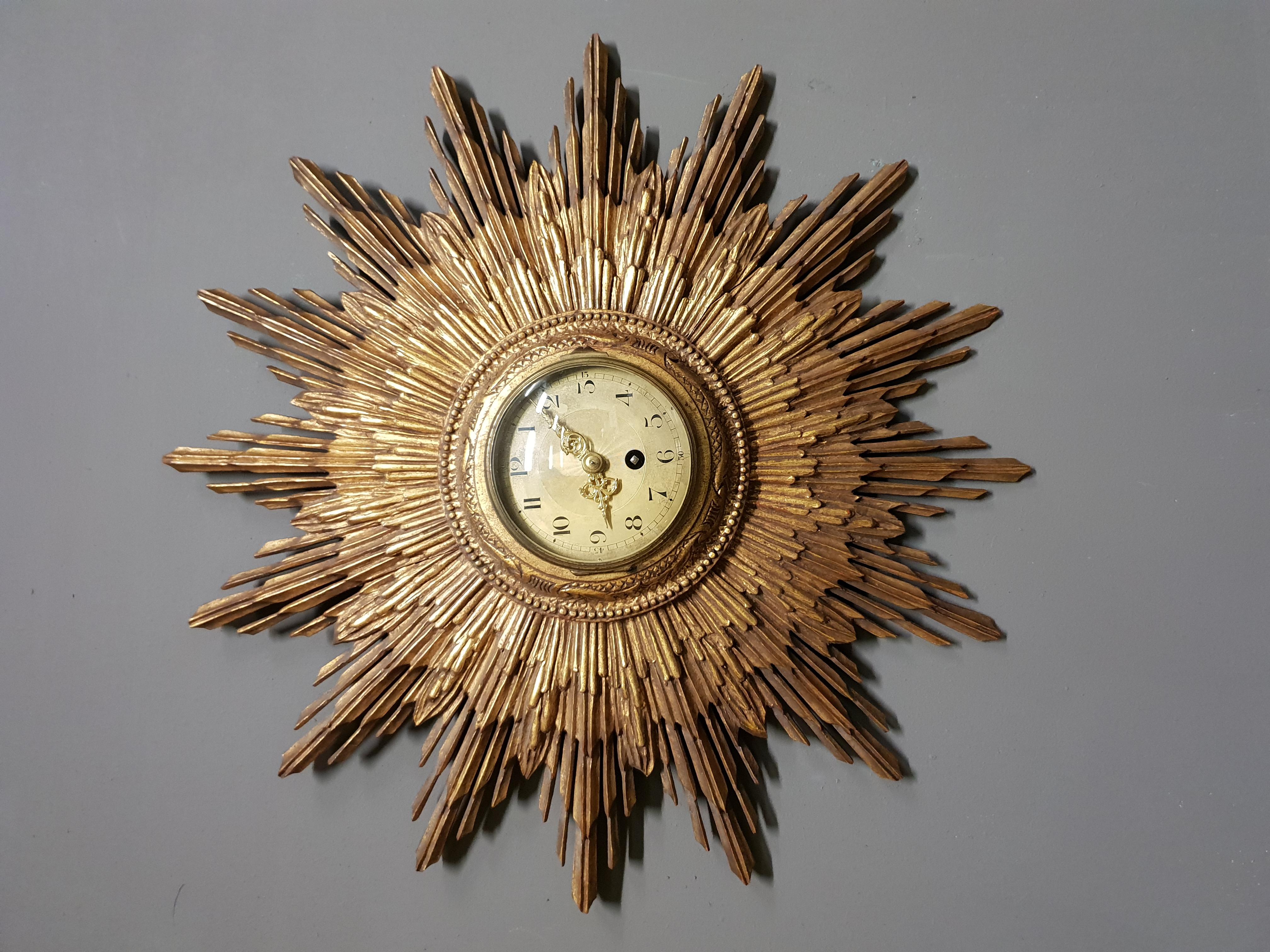 A mindblowing radiant sunburst clock by the French clockmaker Japy Frères, circa 1920.
This impressive and functional wall sculpture is made out of gilded carved wood.
A true piece of art.
The clock is engraved with the Japy Frères brand and