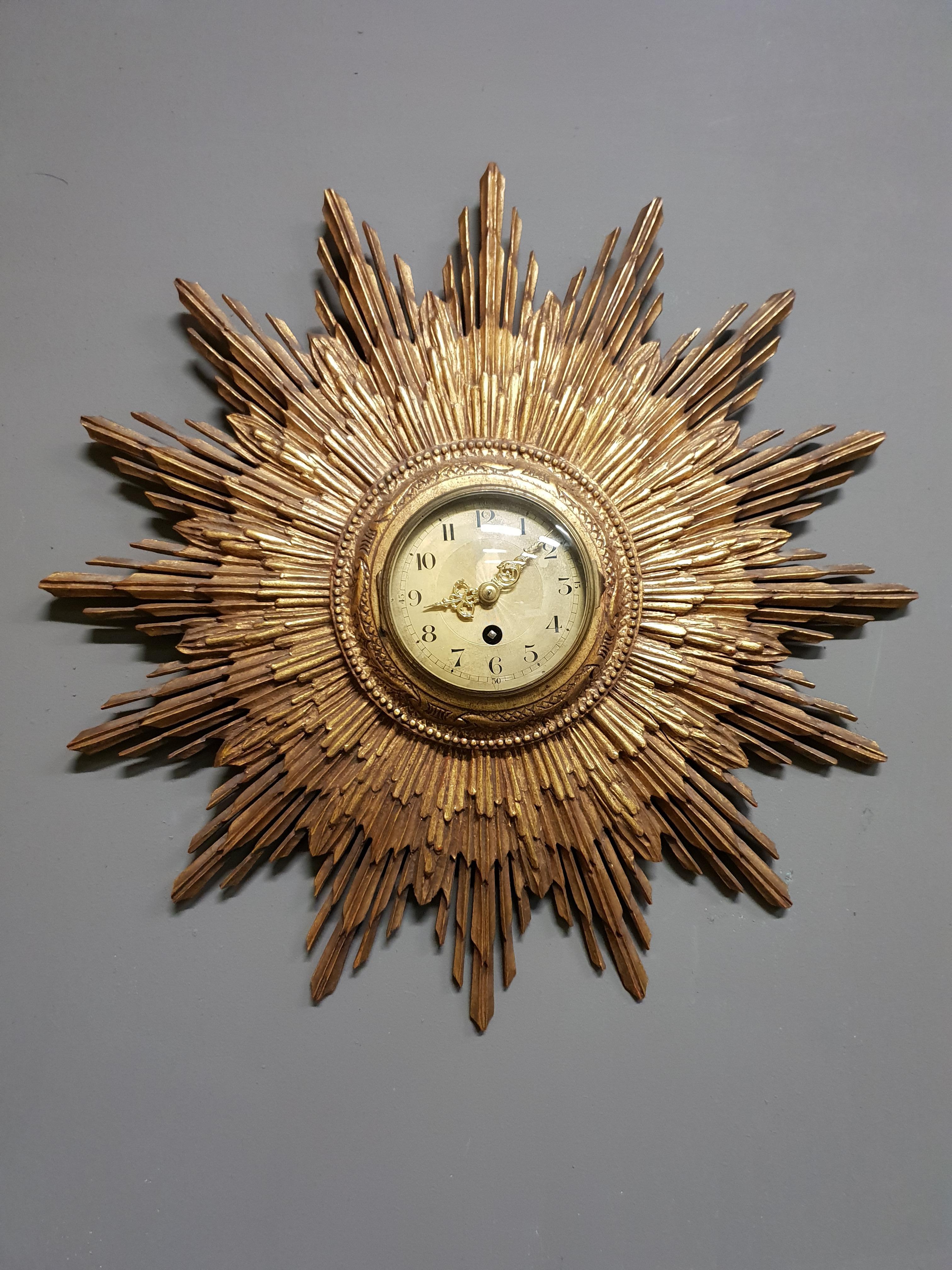 A mindblowing radiant sunburst clock by the French clockmaker Japy Frères, circa 1920.
This impressive and functional wall sculpture is made out of gilded carved wood.
A true piece of art.
The clock is engraved with the Japy Frères brand and