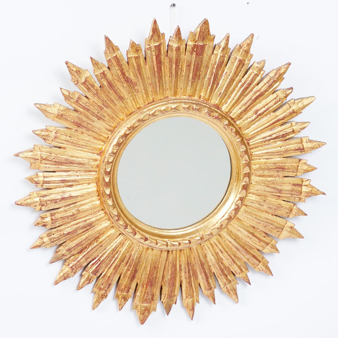 Wall mirror, wood, glass, 1950s, France. Wall mirror with a round mirror surface and a sun-shaped frame made of gold painted wood, with a suspension device on the back, D.50cm, D.4cm.