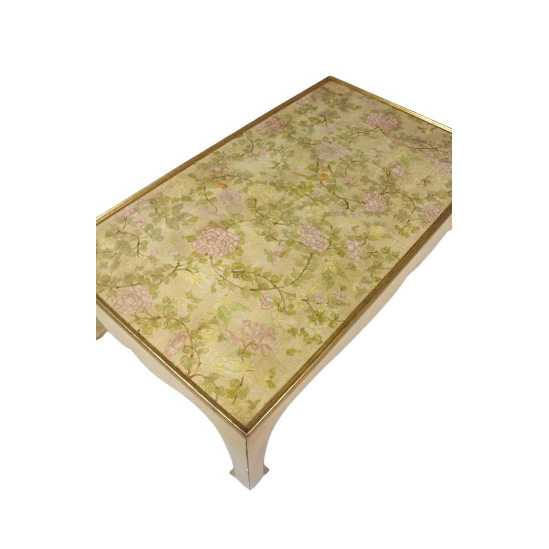 A large gilt and lacquer French coffee table from Atelier Midavaine.  Asian style curved legs with delicately painted flowers, birds and vines decorating the top.  Beautiful, graceful addition to a living room.