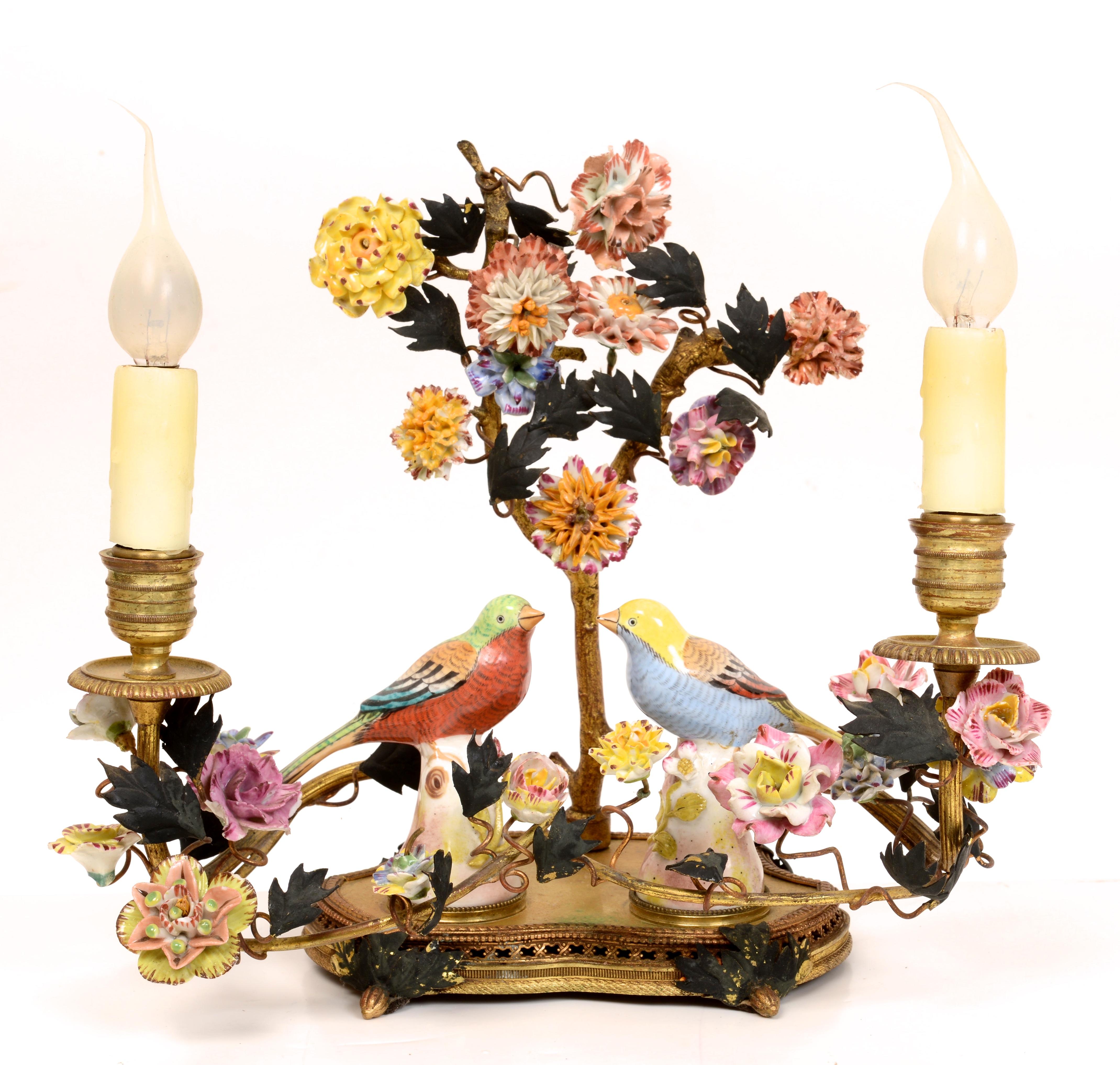 French gilt brass and porcelain boudoir lamp c1920. Ormolu brass or bronze with cold painted details. The back is centered by a tree form with 2 branches and porcelain floral vine. Two candle arms branch out with porcelain flowers on interlaced