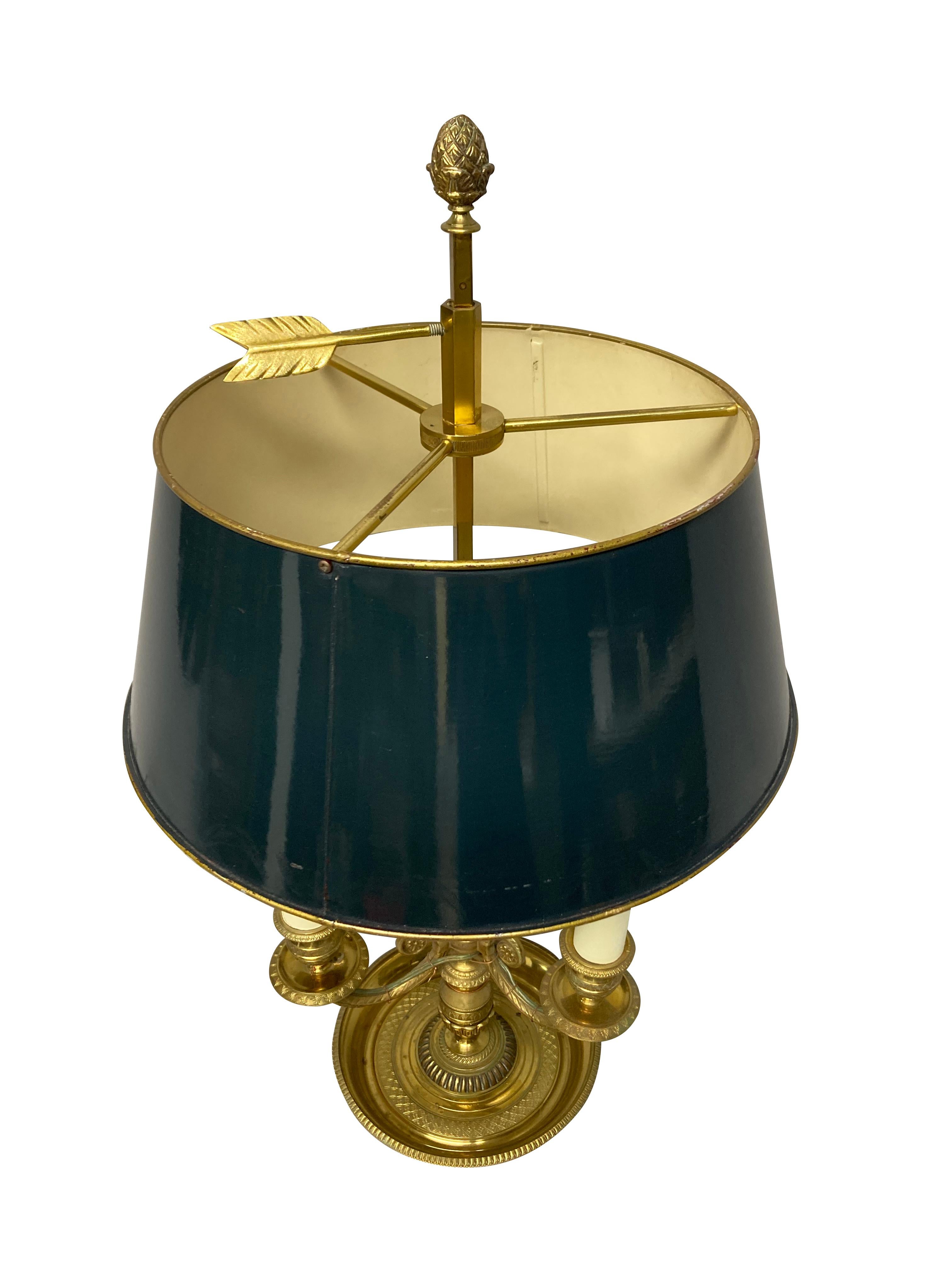 A French gilt brass bouillotte lamp of three branches and an adjustable blue painted tole shade. The detailing and the metal work is very fine, with acanthus, Greek key and acorn decoration. Originally for candles, now electrified.