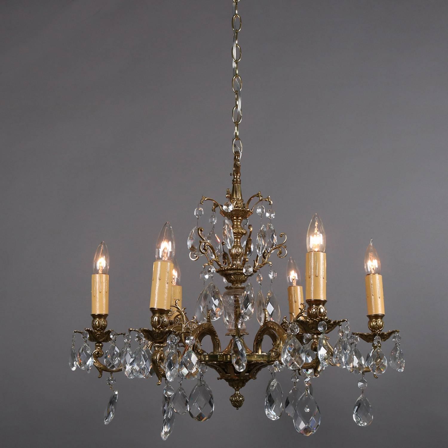 French gilt bronze chandelier features scrolled foliate and floral form frame with six arms terminating in candle lights, cut crystal prisms hung throughout, professionally re-wired, circa 1930.

Measures: fixture 24