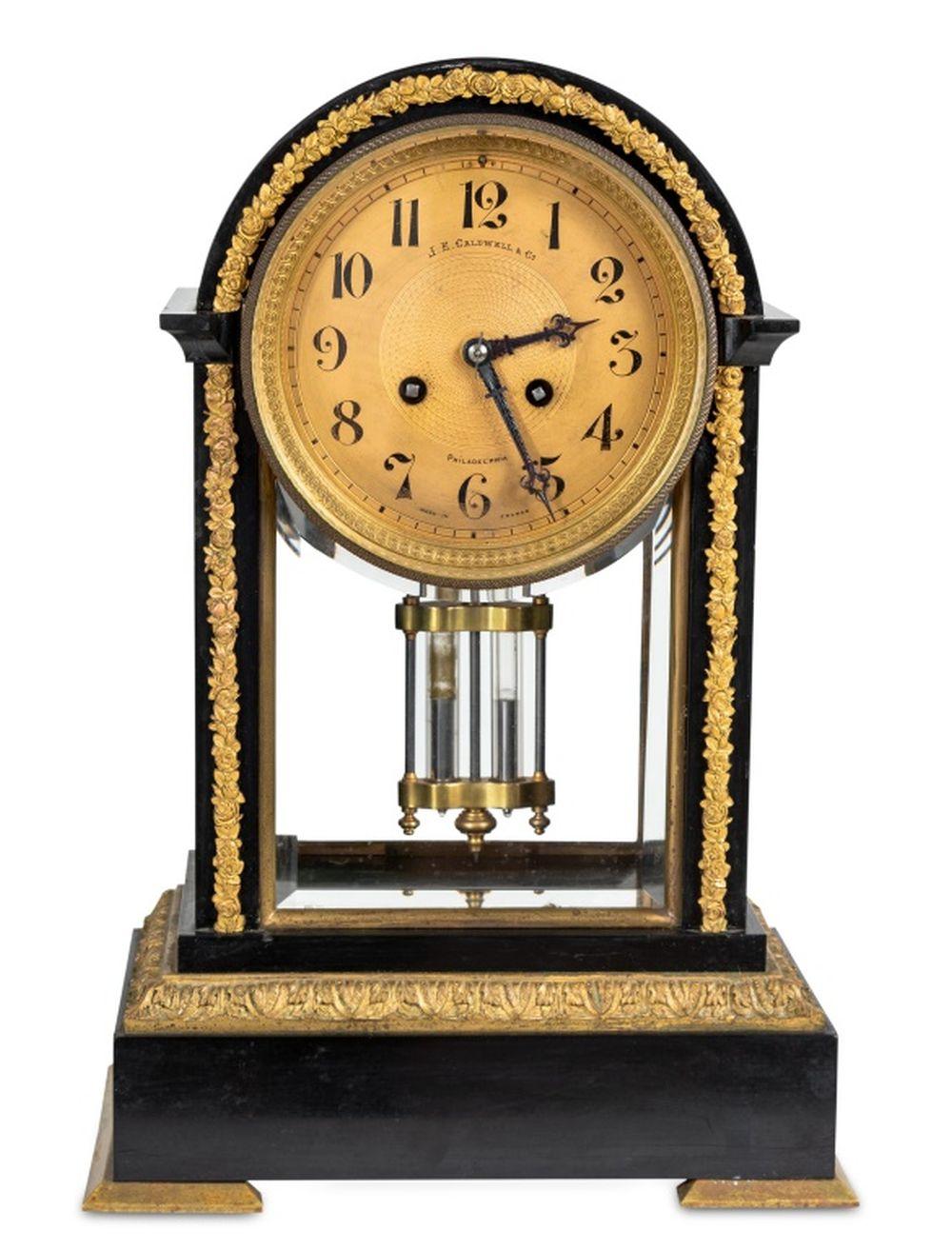 Horloge de cheminée à compensation en bronze doré et ardoise noire, vendue par J.E. Caldwell & Co, Philadelphie, début du 20e siècle, le boîtier arqué de style Empire français, le cadran circulaire en laiton, avec mouvement à gong, signé. 16,25