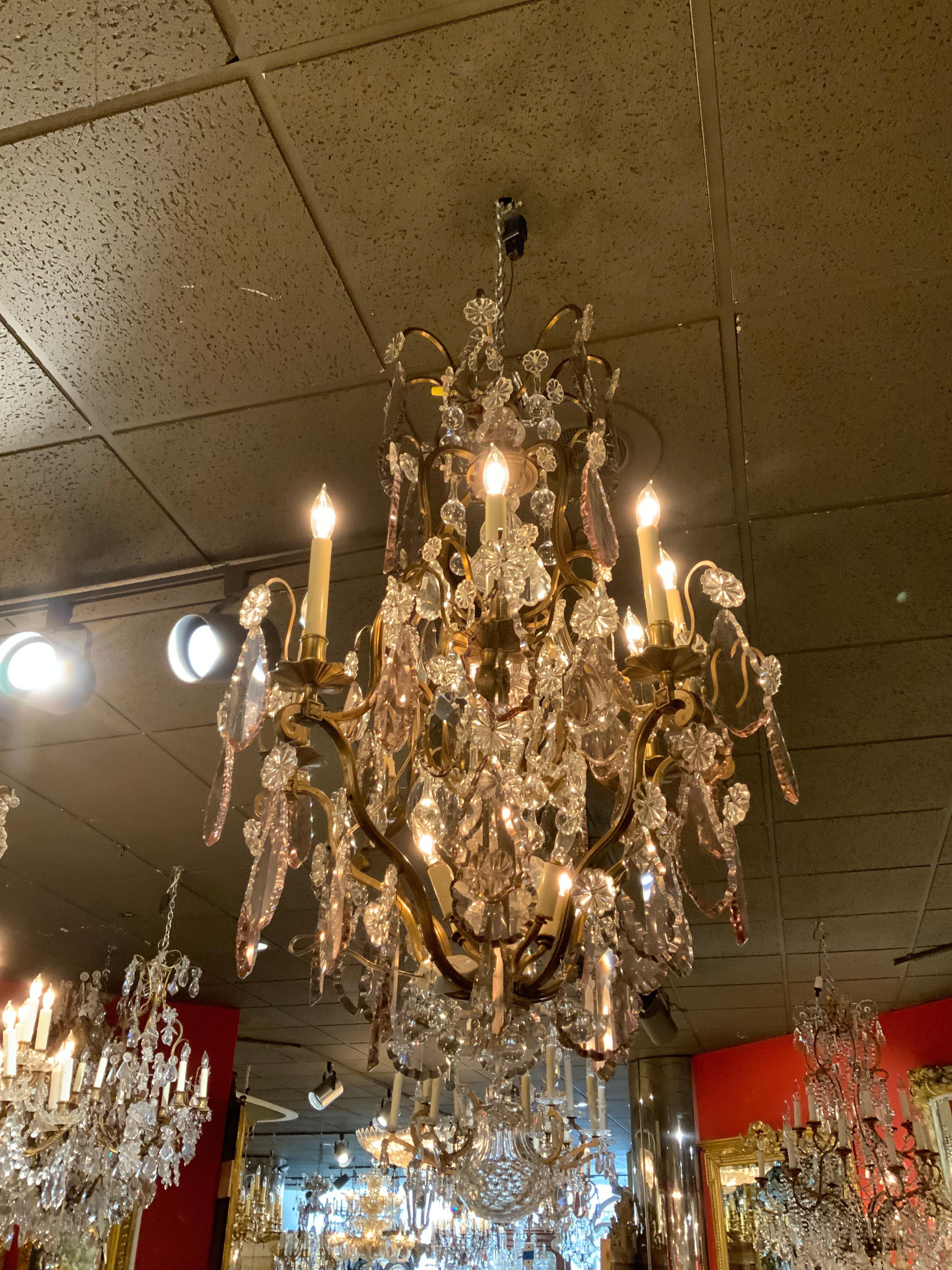 Clear crystal and light lavender crystals make this chandelier exceptional, it has 4 lights 
Inside the cage and 8 lights on the perimeter. The metal work is a soft patina of gilt gold.