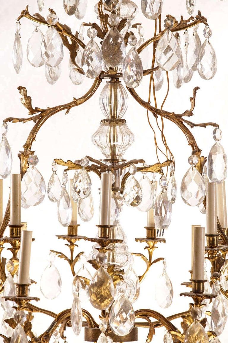 Exceptional French gilt bronze and cut-glass fourteen-light chandelier, the cage with faceted pendants.

Measures: 125 x 100 cm.
Rewired. Repaired. Good Condition. Frame is original, no breaks. Crystal Complete and cleaned. Electricty works