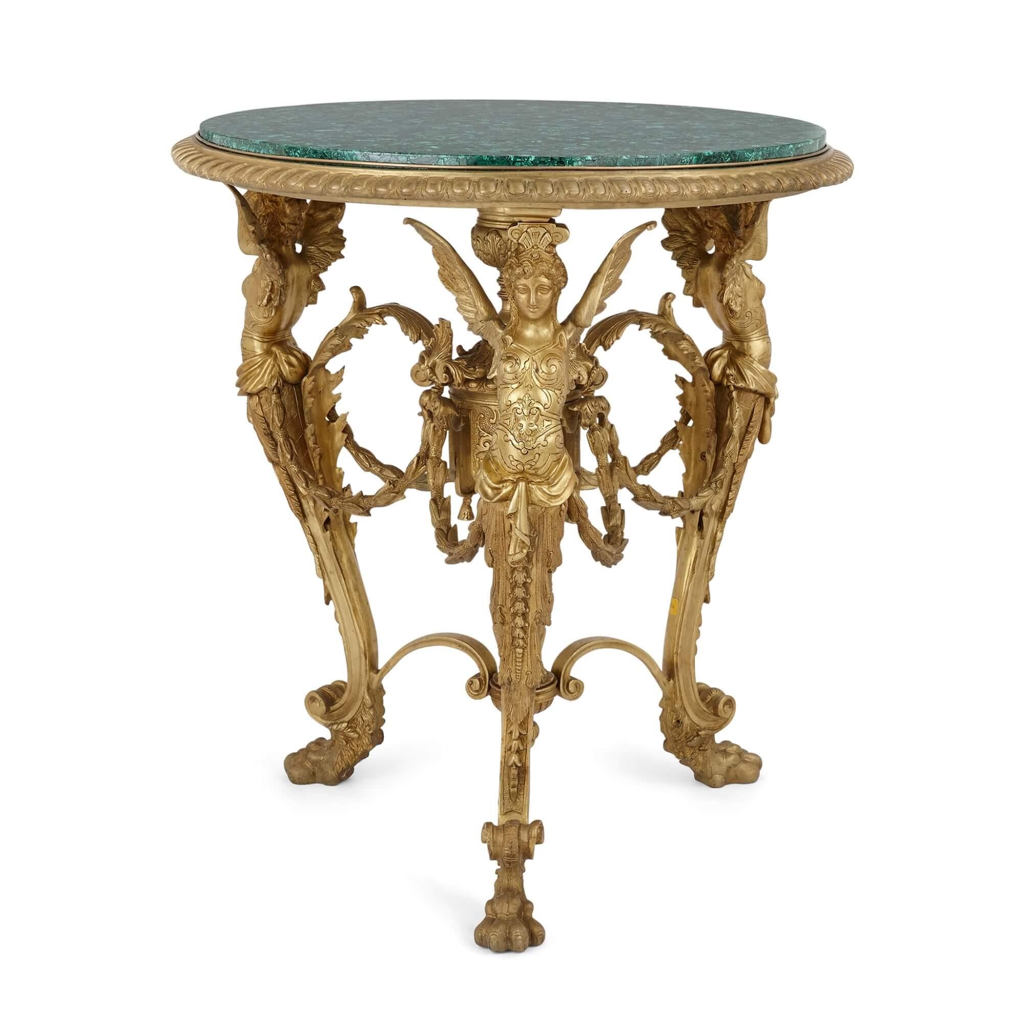 Table centrale en bronze doré et malachite 
Français, 20ème siècle 
Hauteur 79 cm, diamètre 69 cm

Cette très élégante table centrale française du 20e siècle est soutenue par une base ornée de bronze doré de style Empire et surmontée d'un plateau en