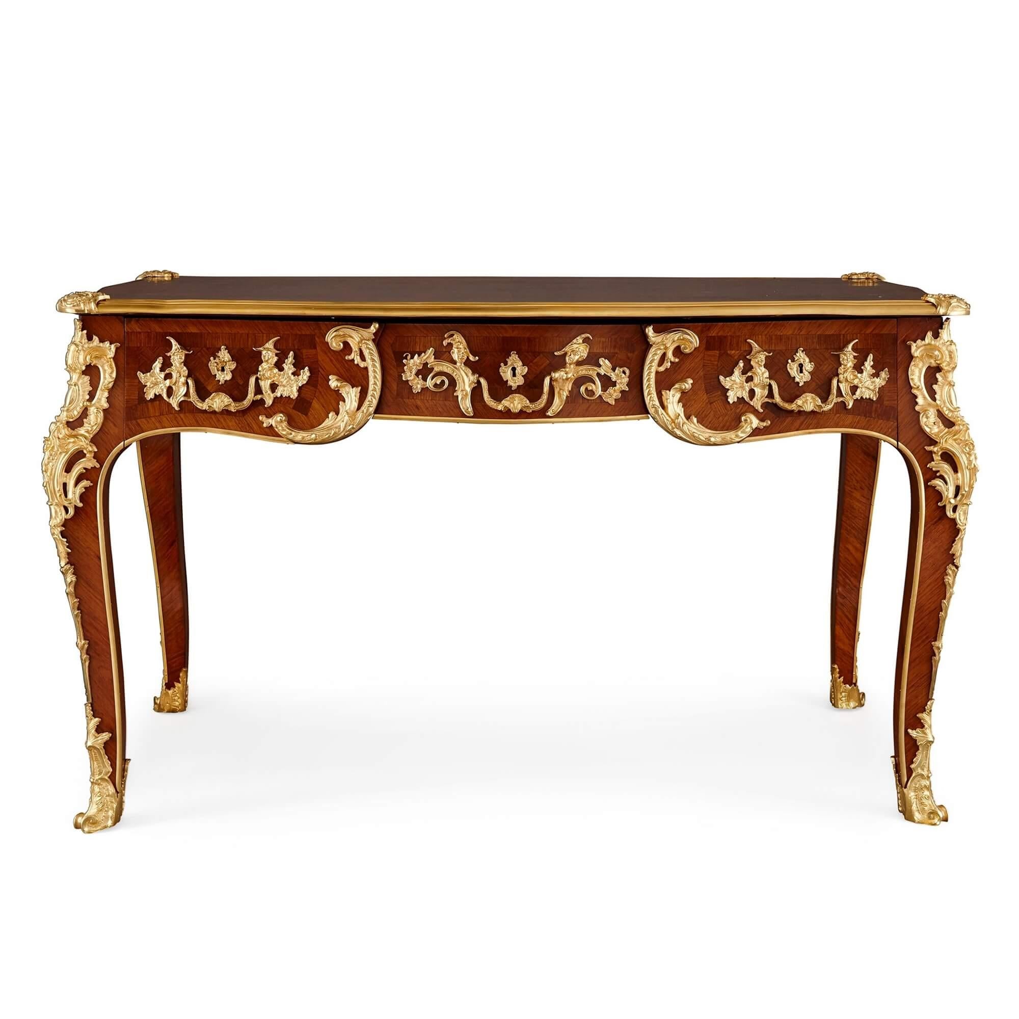 French gilt bronze and marquetry writing desk after Cressent.
French, late 19th century
Measures: height 79cm, width 134cm, depth 76cm

This very fine desk was retailed by the celebrated English retailers Edwards & Roberts and was designed and