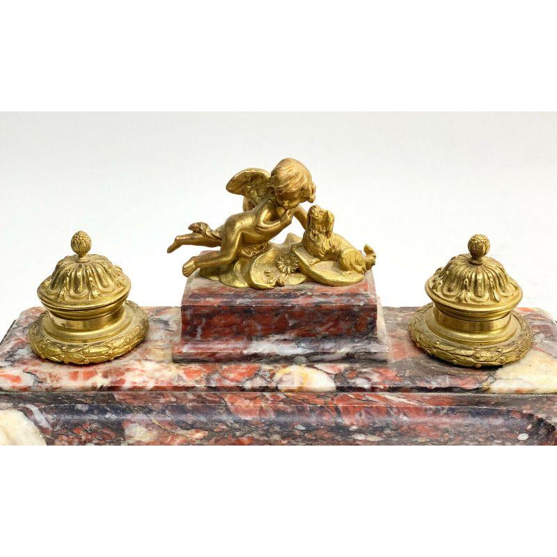 French gilt bronze and red marble cherub with dog inkwell pen stand, 19th century. The gilt bronze areas with a cherub next to a long haired dog. Unmarked.

Additional information:
Color: Red 
Style: French
Primary Material: Bronze 
Material: