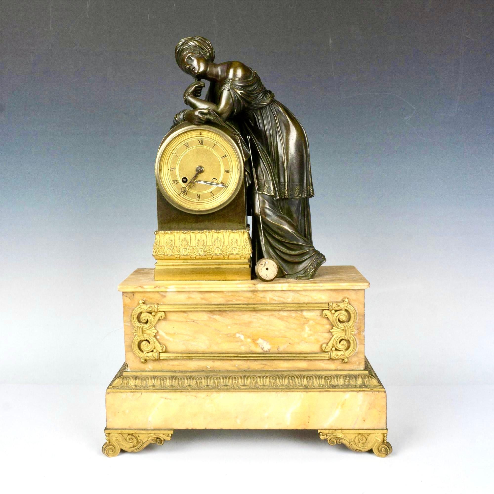 A luxurious and elegant Neoclassical patinated and gilt bronze Minerva standing leaning on the clock, classically robed wearing a turban and standing on a Siena marble plinth . Clock face has Roman numerals.
