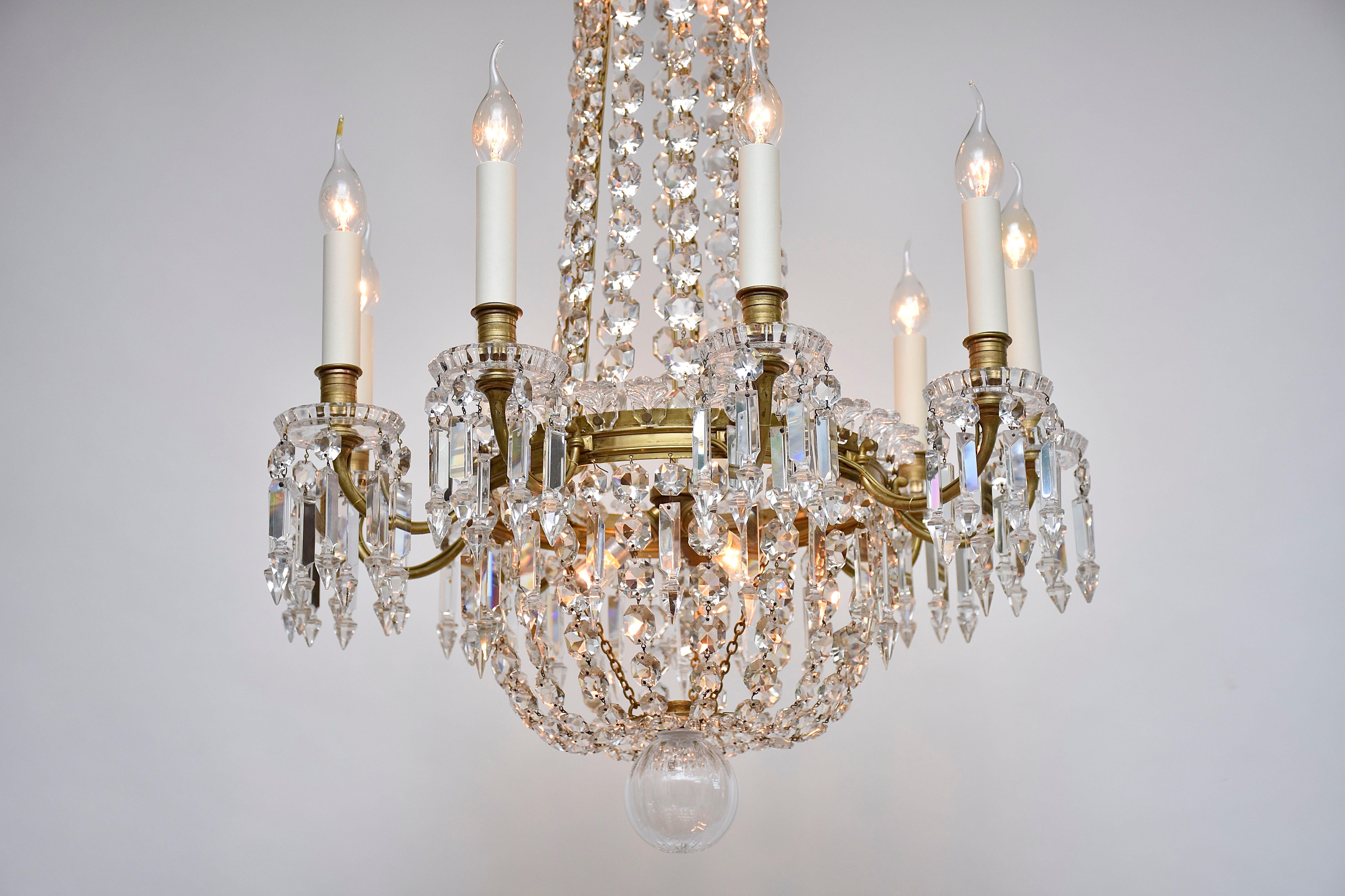 Beautiful French gilt bronze Baccarat chandelier. 
With 9 candle arms around the chandelier and 5 lights inside.
Decorated with strings of faceted Baccarat octagons and drops.
The crown and central ring decorated with mounted acanthus