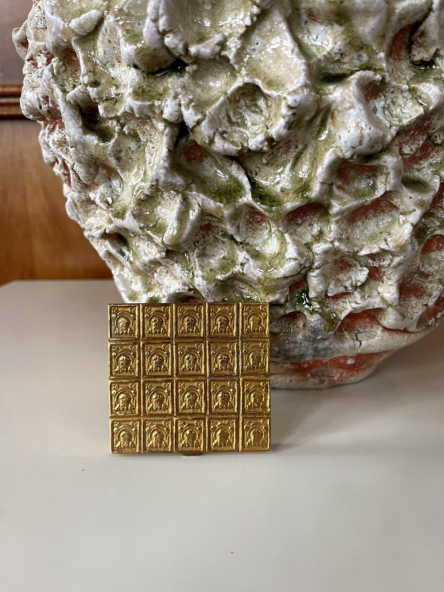 A lovely cast bronze powder box (poudrier) by French Parisian art jeweler Line Vautrin (1913-1997) circa 1950-1960s. The box features a geometrically grid top surface with a four by five repetitive squared reliefs that appears to be religious icons.