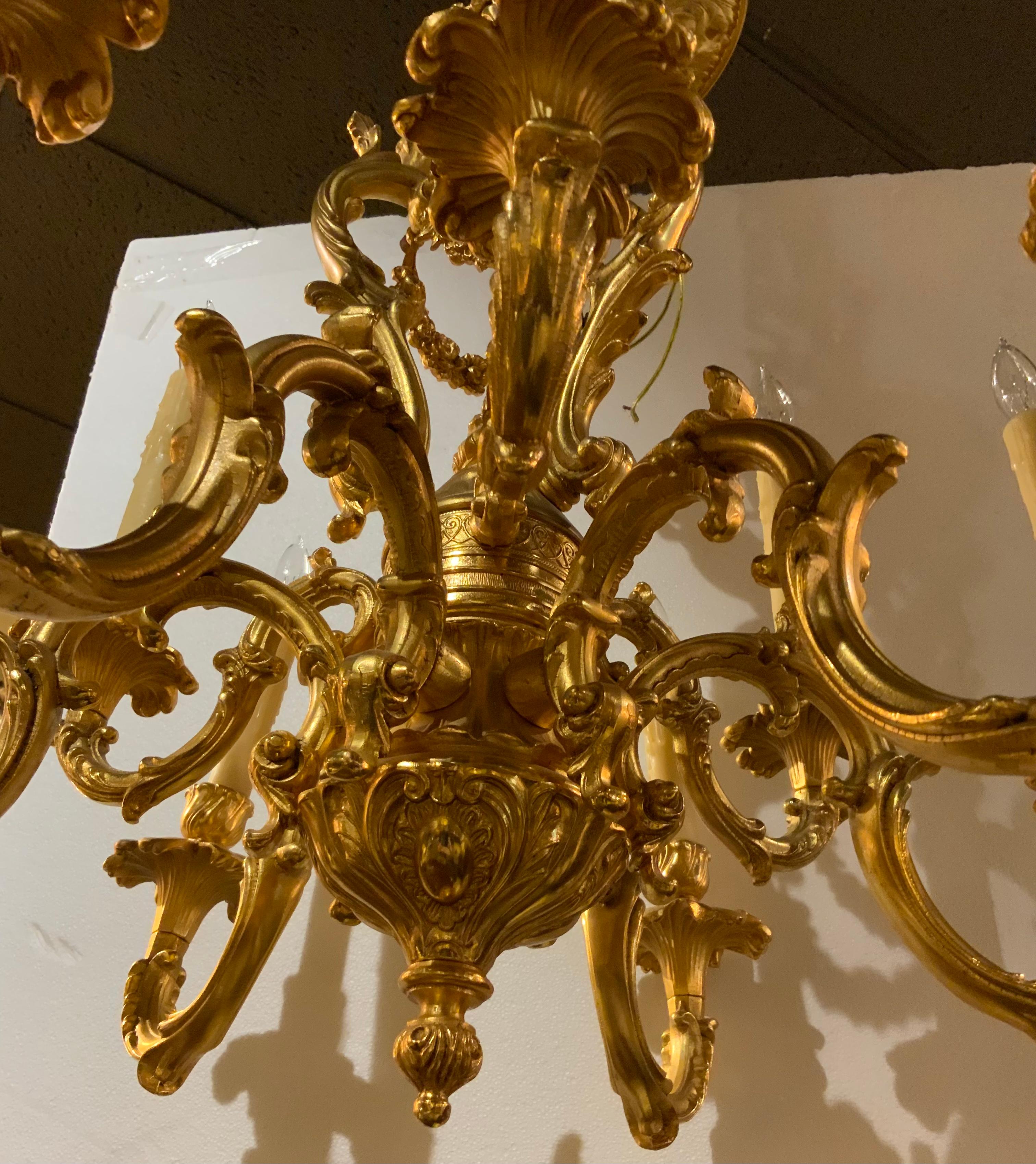 This nine light chandelier is 20 th century with a central standard decorated
With floral swags issuing a tier of three arms over six arms, electrified.
The wiring is good and ready to hang. It has a chain that is exceptional 
And a canopy that