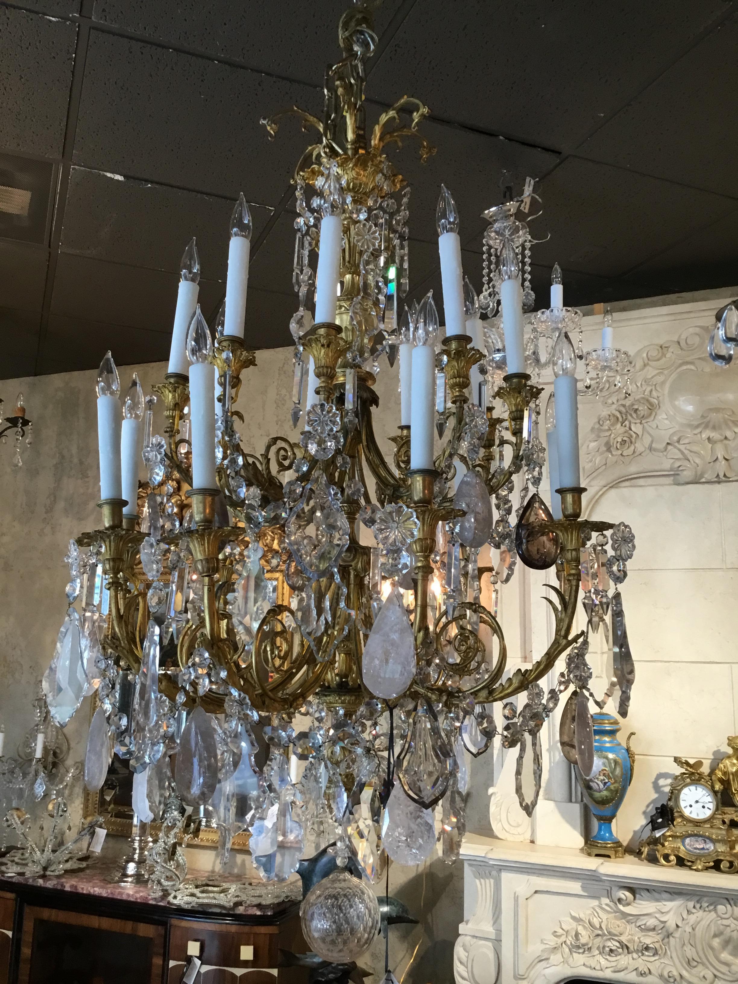 FrenchGilt bronze  and crystal chandelier with
rock crystal,   and clear crystal, with eighteen lights. Exceptional gilt bronze cage 
With urn shape in the center. A lovely finial holding the large clear ball. Wax sleeves
Large swirling arms support