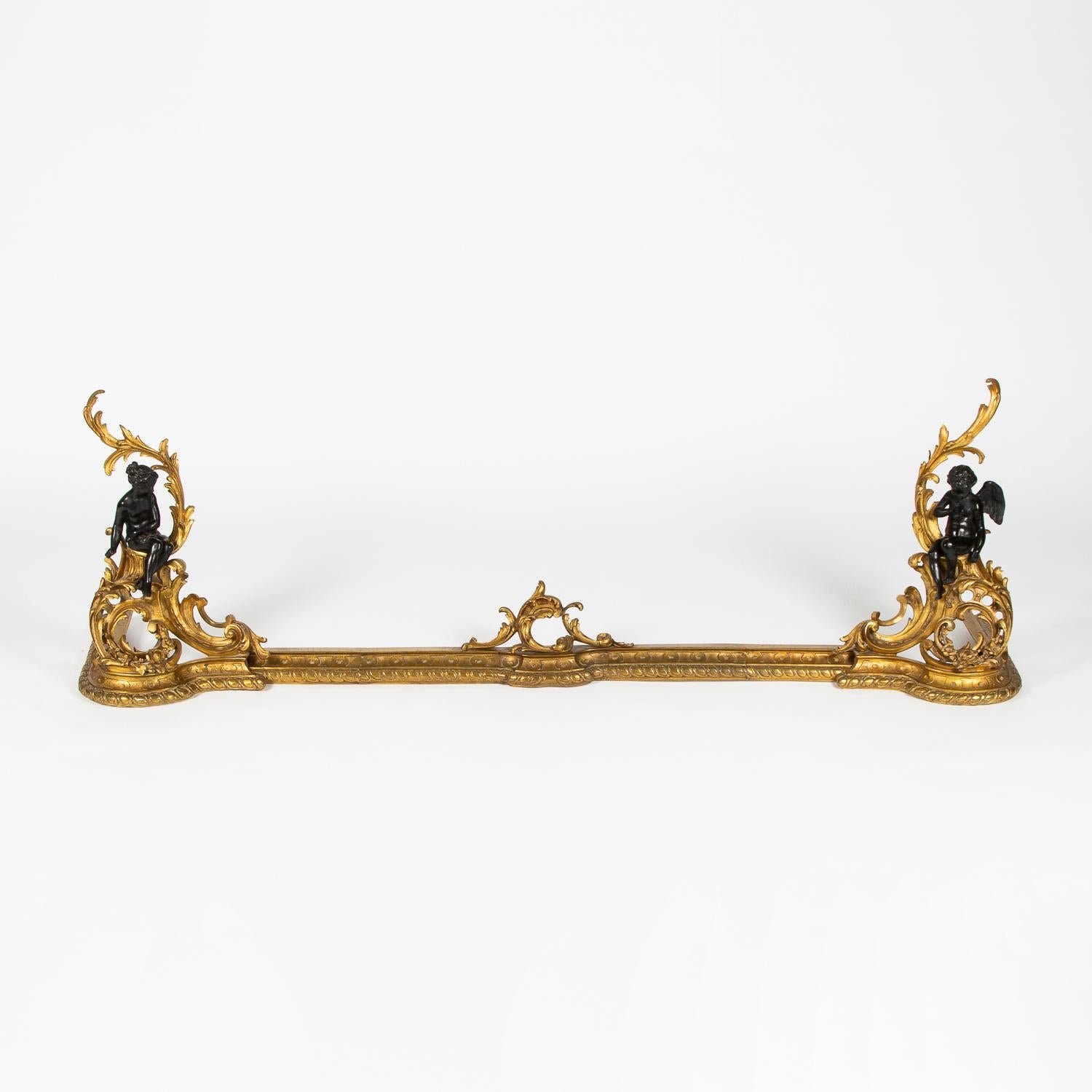 A late 19th century French gilt bronze chenet, in the Louis XV style, with fender of adjustable width.

Each end with classical figures sitting within floral scrolls.

Maximum width: 64 inches - 162 cm.

Minimum width: 46 1/2 inches - 118