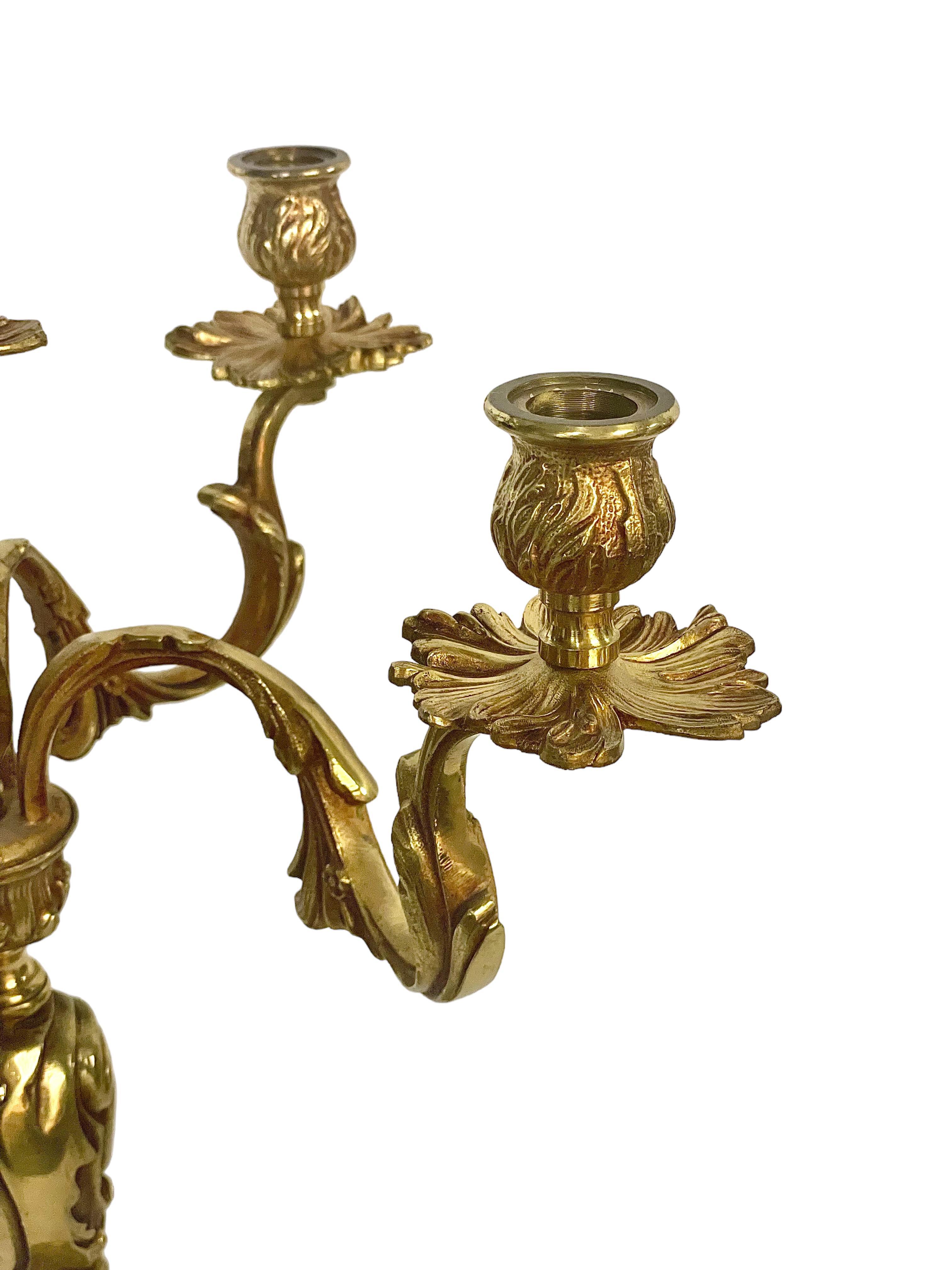 A large and ornate solid gilt bronze five-arm candelabra, with finely chiseled detailing in the Rococo style. Each of the five arms takes the form of scrolled acanthus leaves, and terminates in a goblet-shaped candle holder sitting above a shaped