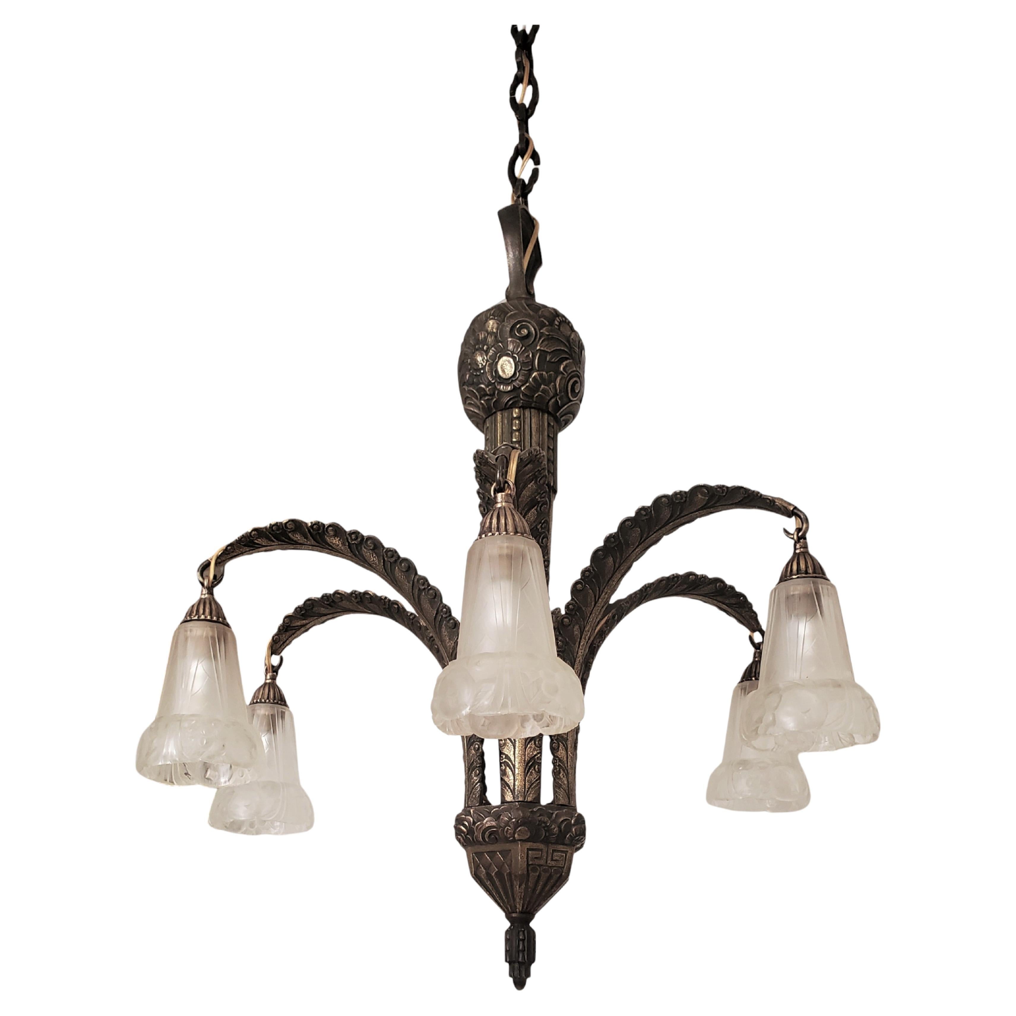  
This unique French Art Deco bronze palm chandelier by Paul Gilles features a captivating and warm gilt bronze finish, with six fluid arms in a stunning tropical arrangement. 
Each feather arm is adorned with exquisitely molded frosted art glass