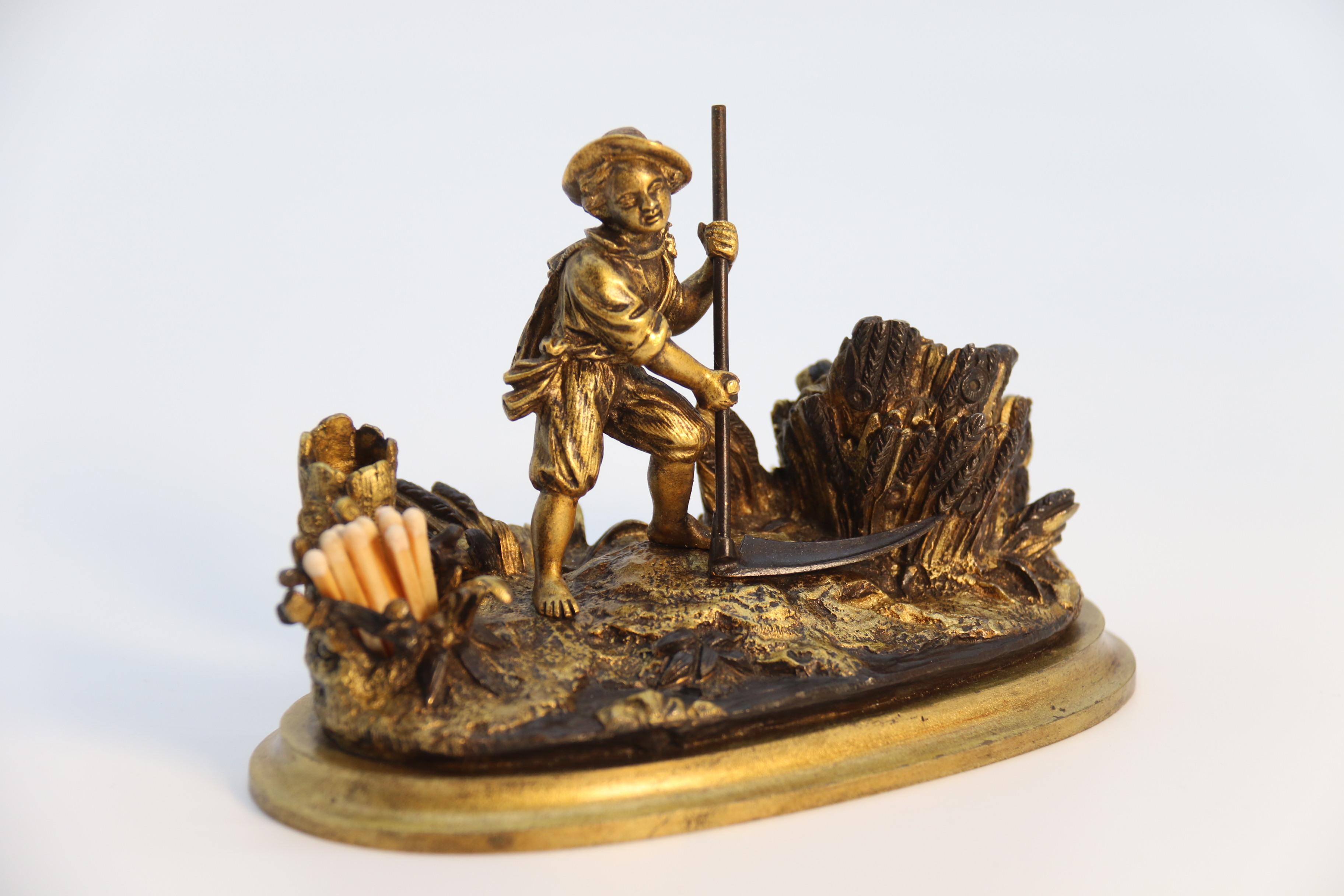 This wonderfully detailed bronze inkstand is of unusably small proportions and was made to compliment a lady's writing table most likely. It is of an oval form with a moulded base which is mounted with a detailed bronze study of a rural scene of a