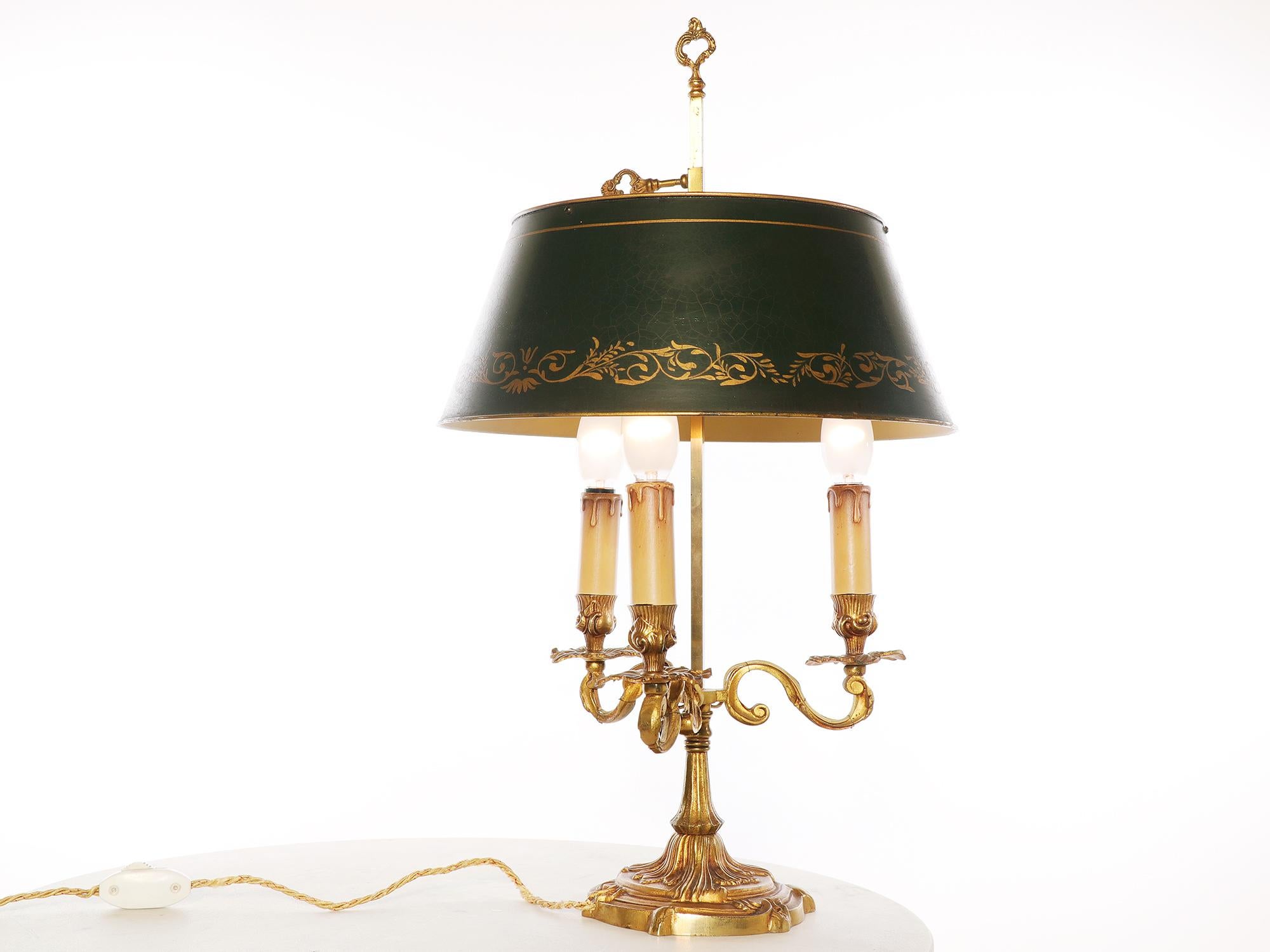 Elegant antique French gilt bronze Louis XV style Bouillotte lamp with a painted metal shade and three electrified candle- arms.
The lamp takes three small Edison bulbs, it originally used candles and was converted to an electric lamp in the early