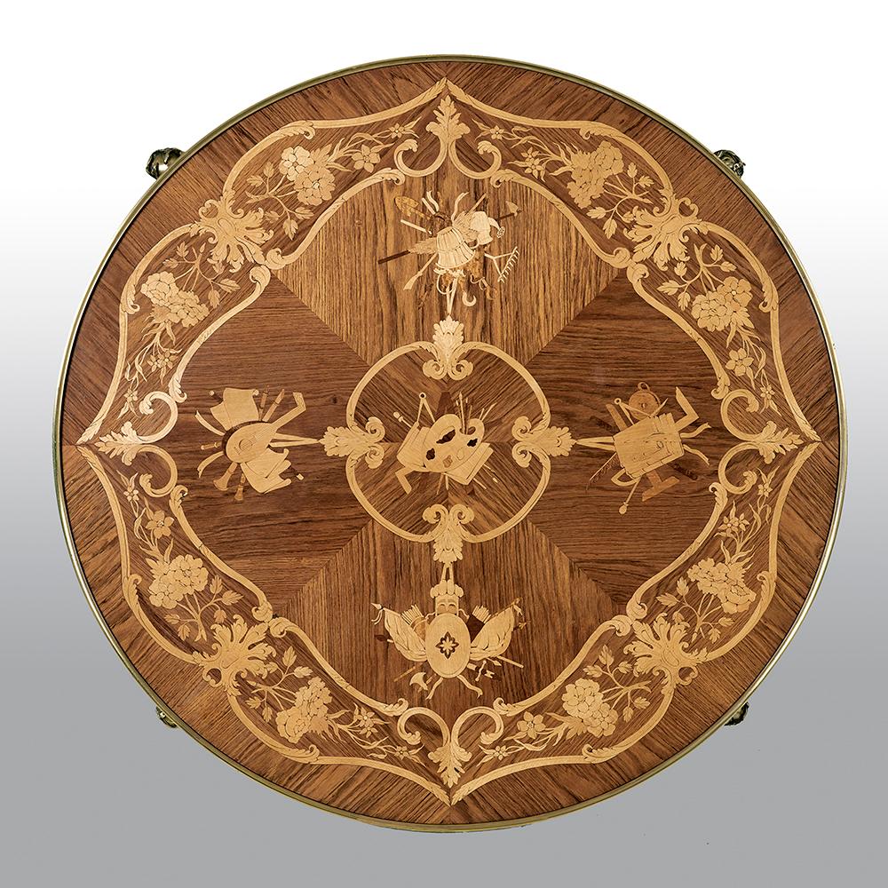 A fine French 19th-20th century Louis XV style gilt bronze-mounted kingwood and satinwood marquetry center table. The circular top inlaid with floral design marquetry. The apron centered with ormolu mounts of scrolling foliage, the four legs with