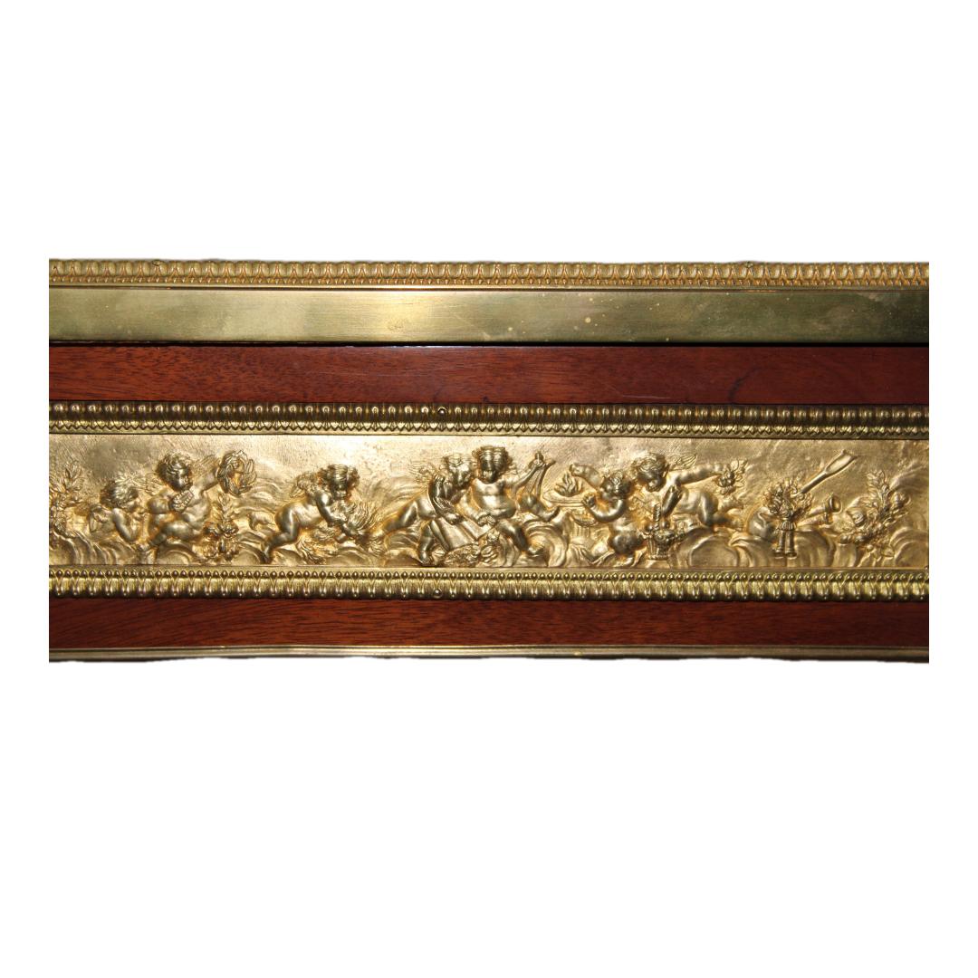 C. 19th Century

Louis XVI gilt bronze mahogany parquetry bureau plat. Rectangular trellis work above three drawers, with scrolling basket handles and relief plaques depicting putti. After Jean-Henri Riesener. Late 19th C.  A similar piece sold at