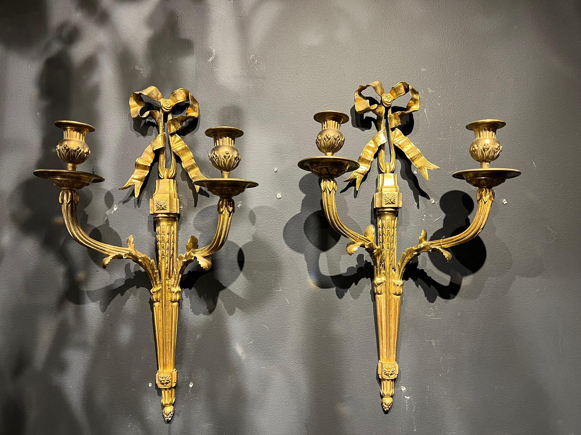 A pair of circa 1920’s French gilt bronze sconces with ribbon design on top and two arms. In very good vintage condition. 

Dealer: G302YP 