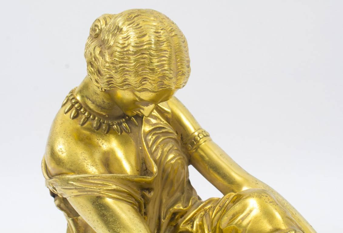 A beautiful French gilt bronze sculpture of a study of the seated poet Sappho, signed J. Pradier, with Suisse Freres foundry mark, circa 1830 in date.

The sculpture portrays the classically dressed poet Sappho seated on a stool with a lyre, deep