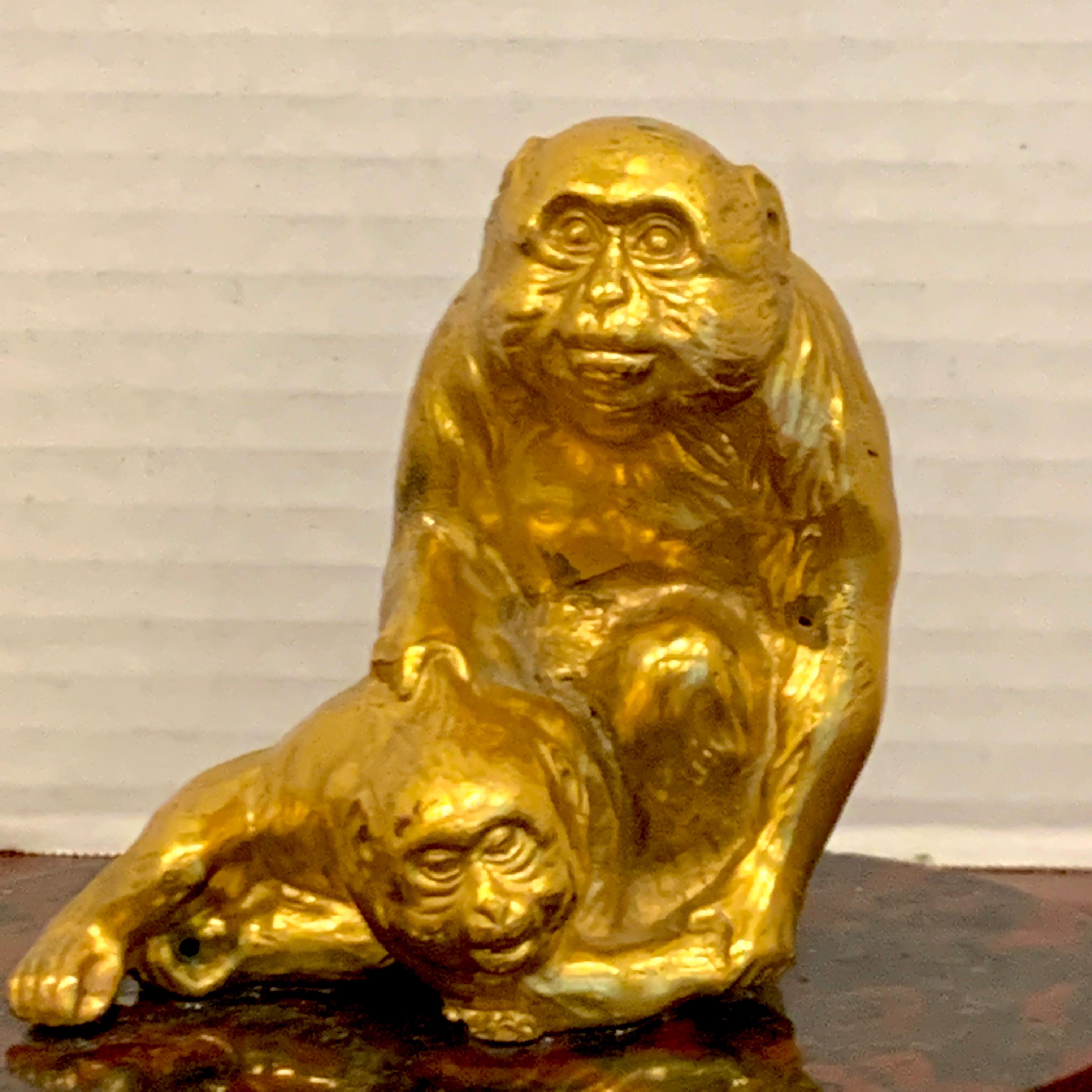 Sculpture française en bronze doré représentant des singes assis, joliment détaillée, deux primates assis expressifs, fixés à une base ovale en marbre sanguin, non signée.
   