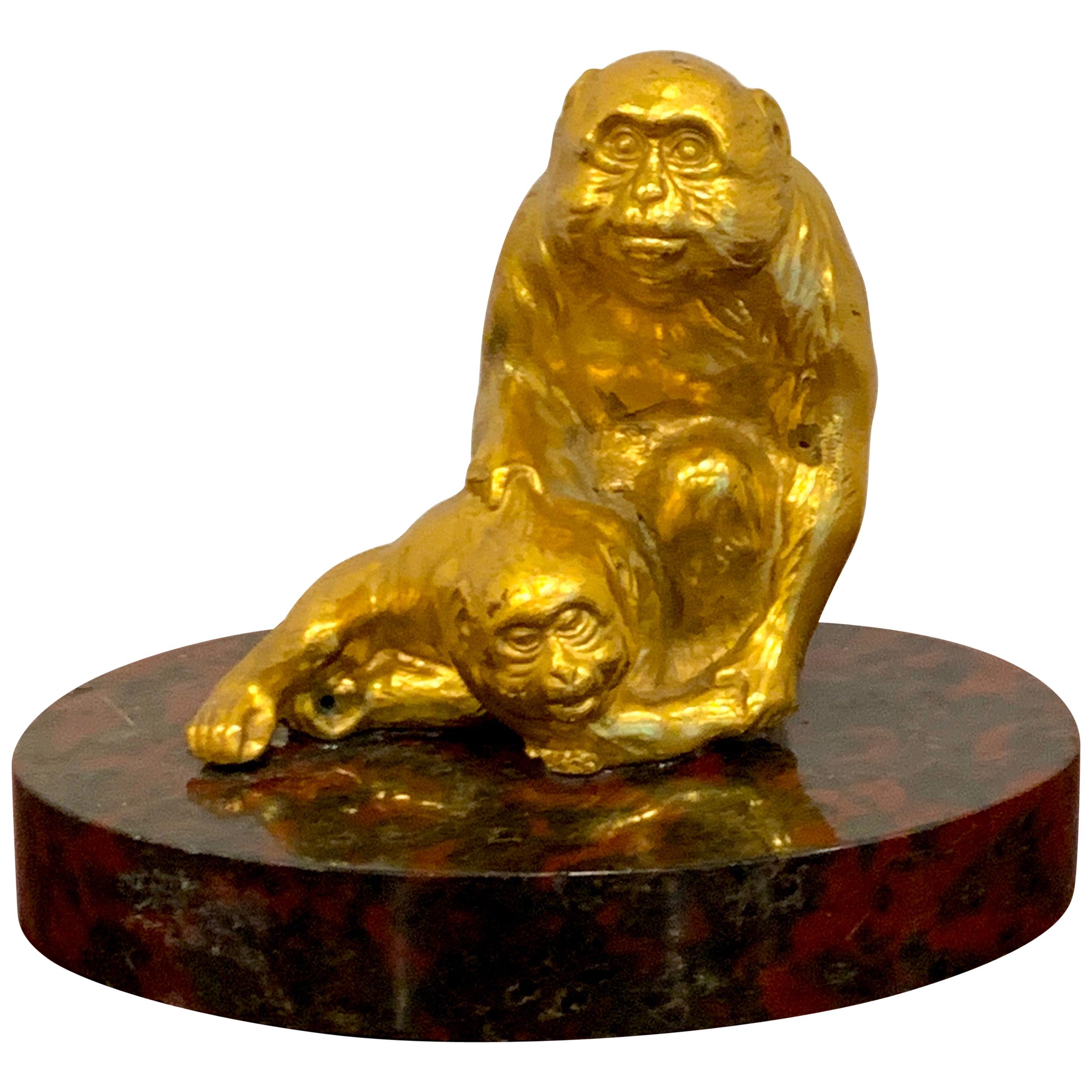 Escultura francesa de bronce dorado de monos sentados