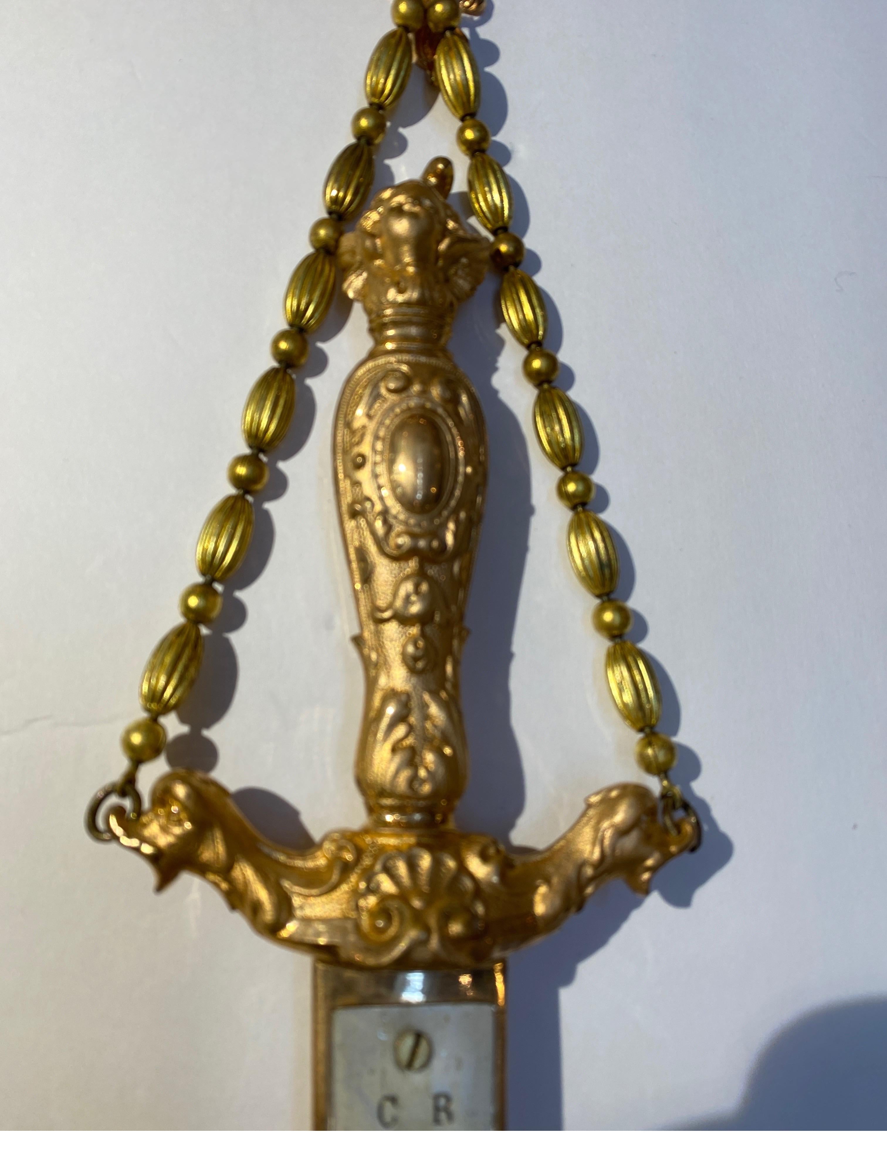 Elegant gilt bronze hanging thermometer in the form of a dagger.. The lion form top with beaded gilt chain with bagger form gilt bronze with mounted thermometer, registers in Celsius. Elegant piece for a weather enthusiast of scientific collector.