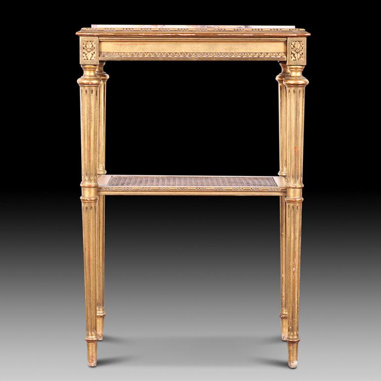 Lovely quality French 19th century gilt two-tier side table with a marble top set within a carved perimeter, and lower shelf with caning. Fine turned tapering fluted legs. C. 1890.