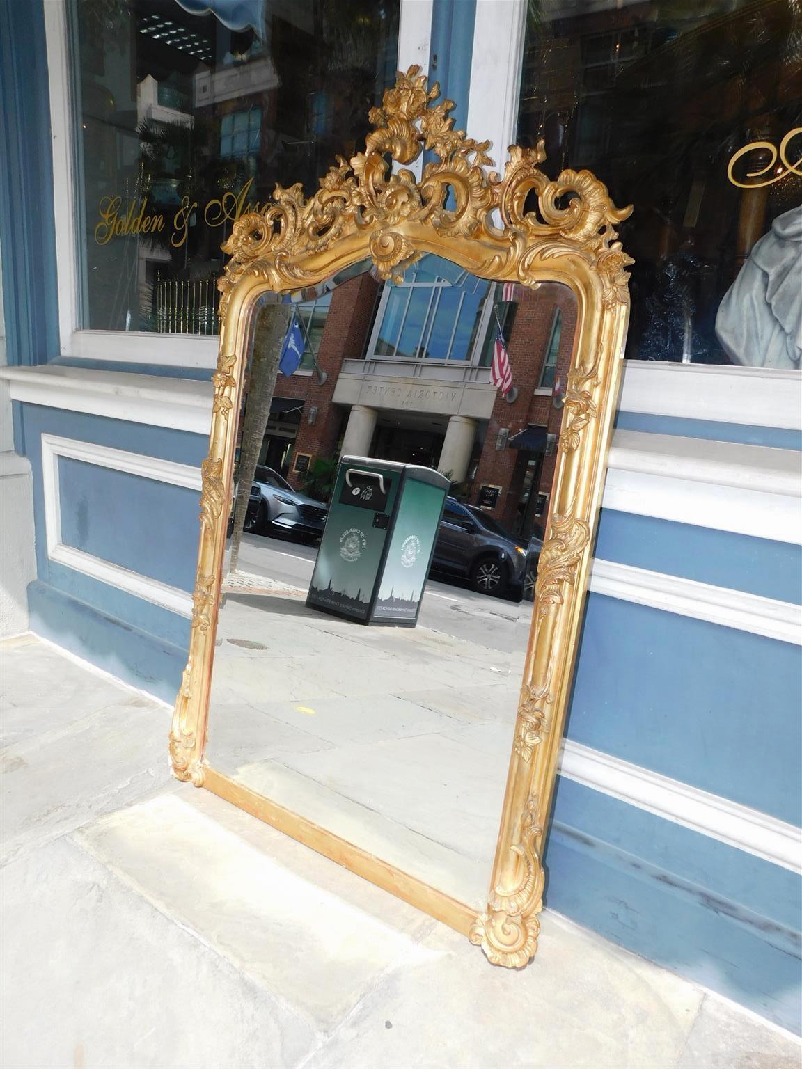 French gilt carved wood and gesso foliage wall mirror with the original beveled glass. Mirror retains the original wood backing, early 19th century.