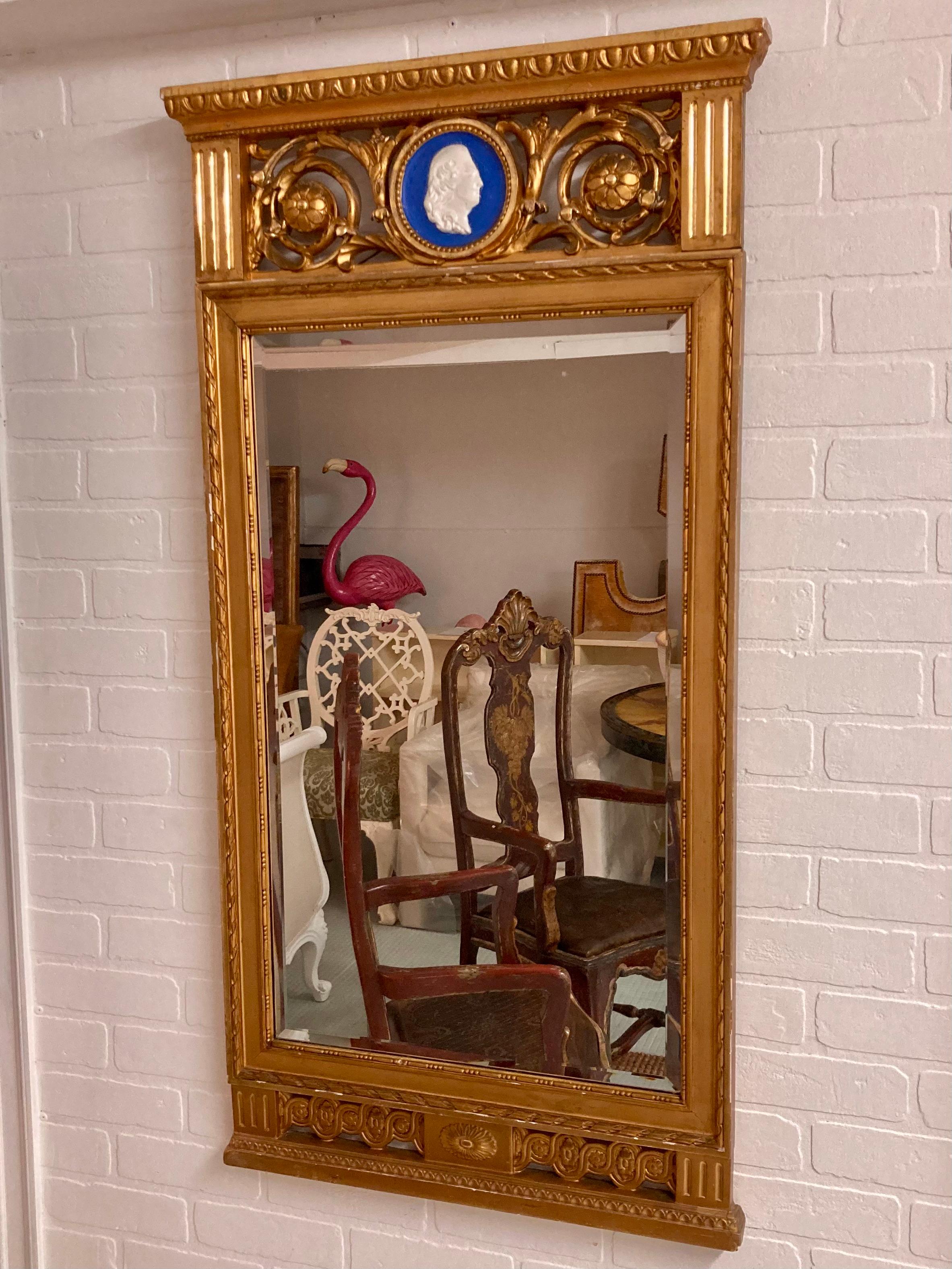 Magnifique miroir classique français doré avec plaque de style Wedgewood. Magnifiques détails sculptés et finition dorée de qualité. Ajoutez un peu de style français à votre maison.