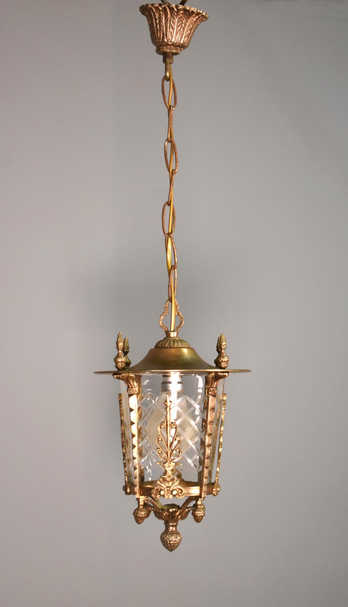 Lanterne d'entrée dorée à la française

Cette lanterne de salle française dorée présente un abat-jour en verre taillé transparent d'une seule pièce, entouré d'ornements décoratifs et de fleurons au-dessus et en dessous.

La lanterne est suspendue au