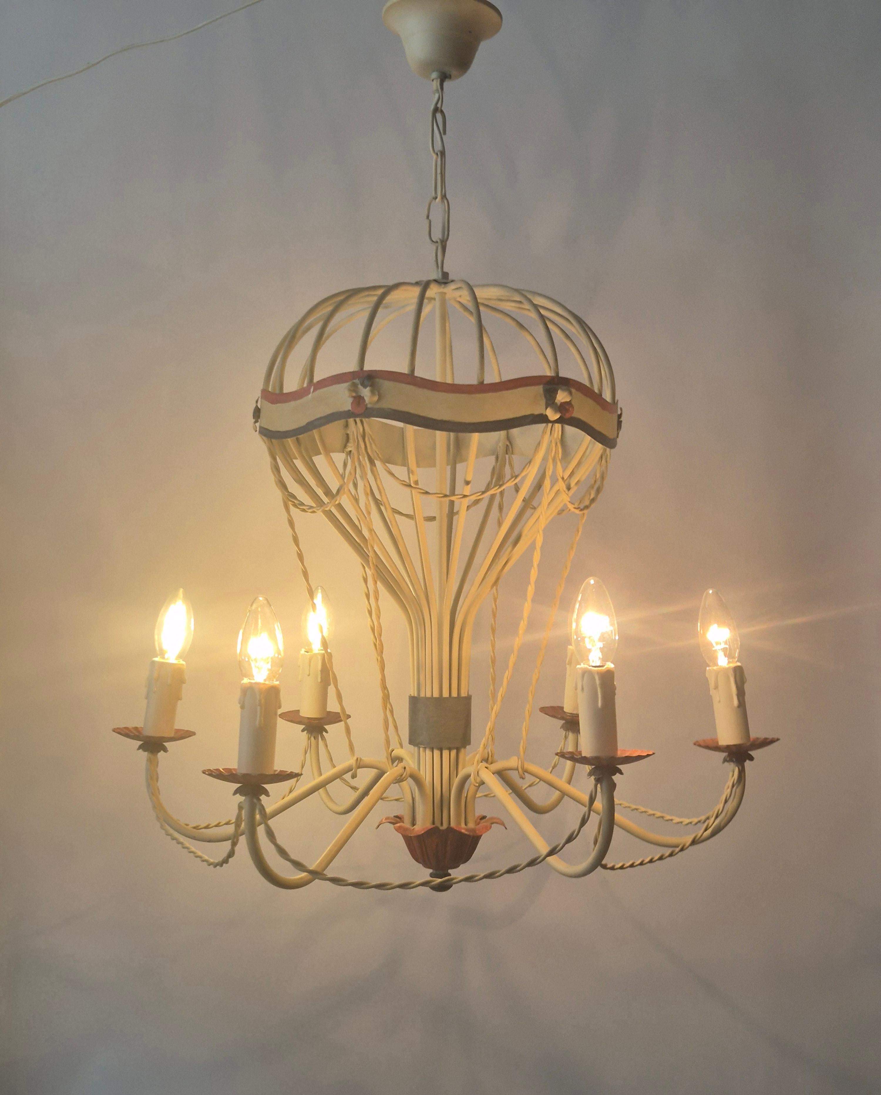 Chandelier in the shape of a hot air balloon, mid-20th century. A whimsical structure with arched metal rods forming an open dome, and decorative draped garlands.

The chandelier has six arms extending outward at the base, each holding a