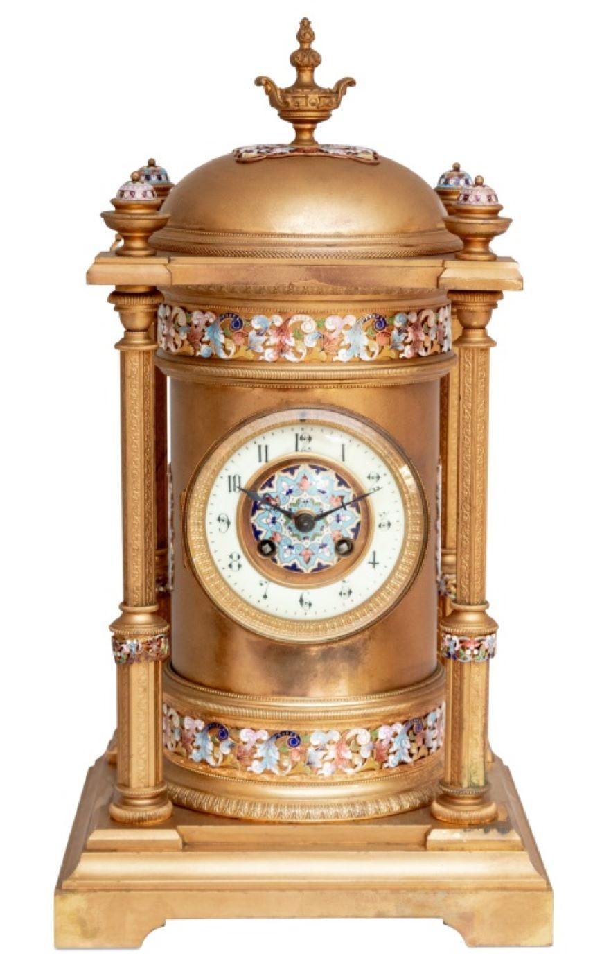 French Gilt Metal and Champleve Enamel Clock, late 19th century, of architectural form, the circular enamel dial, with strike on gong movement, the domed top supported by four columns on a stepped square base. 17.5