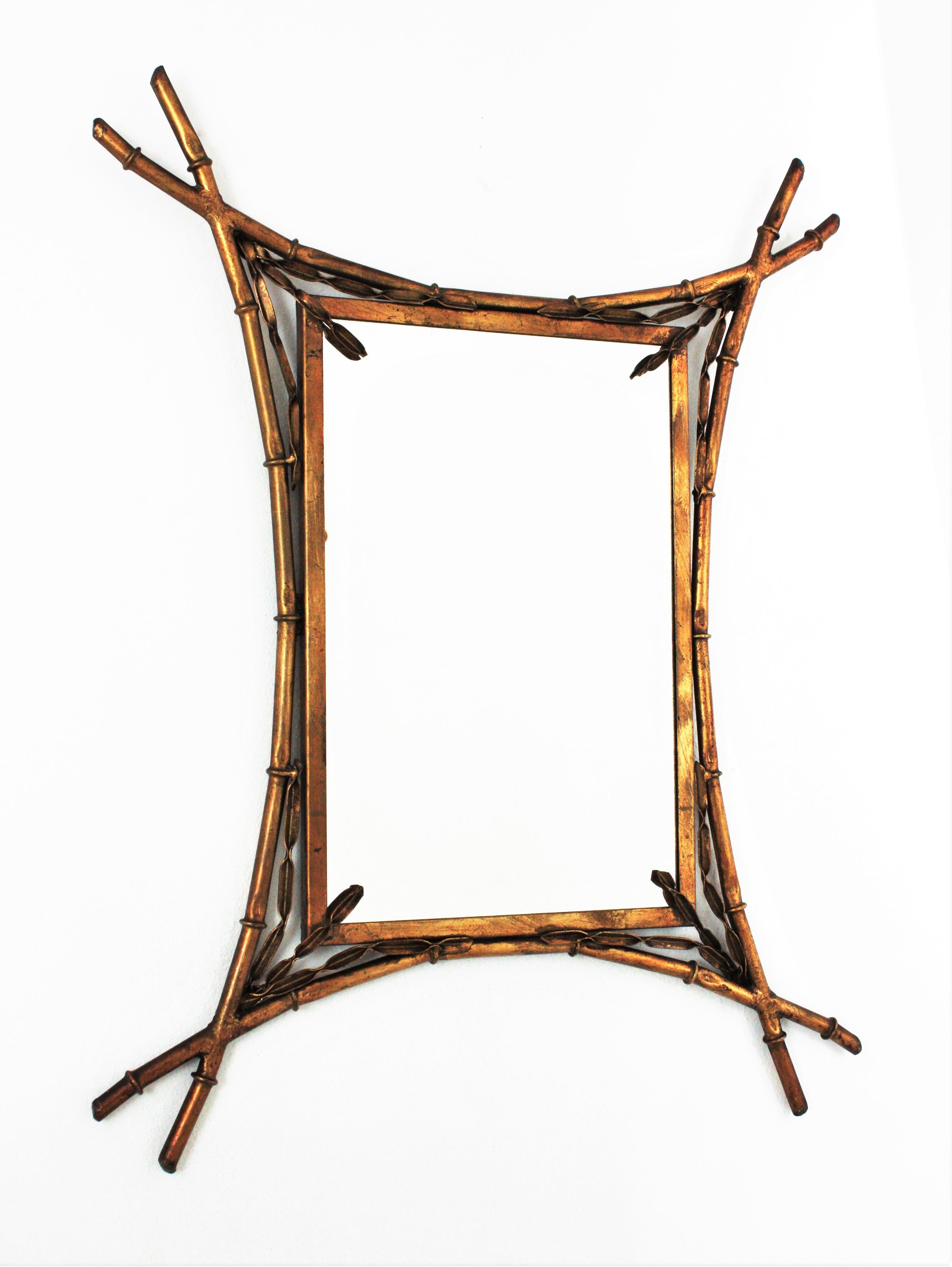 Eye-catching faux bamboo rectangular mirror with leaf motifs. France, 1930s.
The frame has an elegant design with curved faux bamboo gilt iron canes and foliage motifs adorning the corners.
handcrafted in gilt wrought iron.
This wall mirror will be