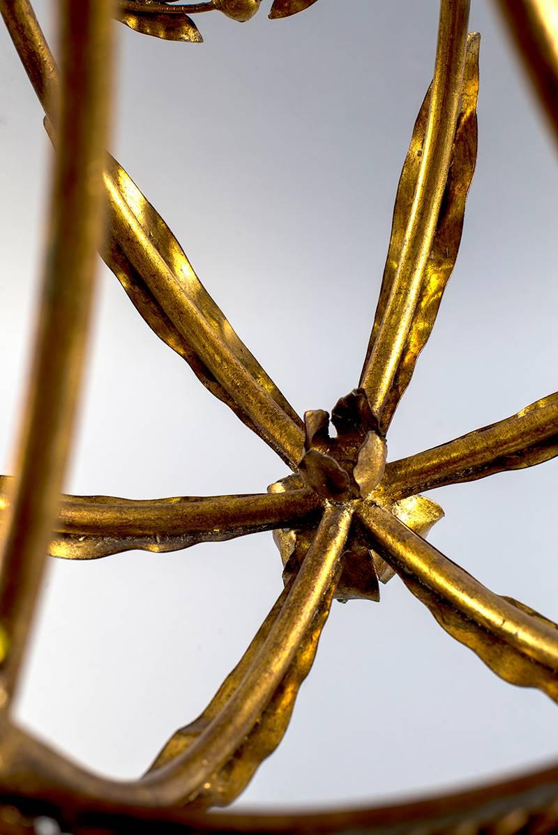 French chandelier has a gilt metal frame with draped leaf garland, four candle style lights and wooden bobeches, circa 1920s. New electrical wiring for US standards.