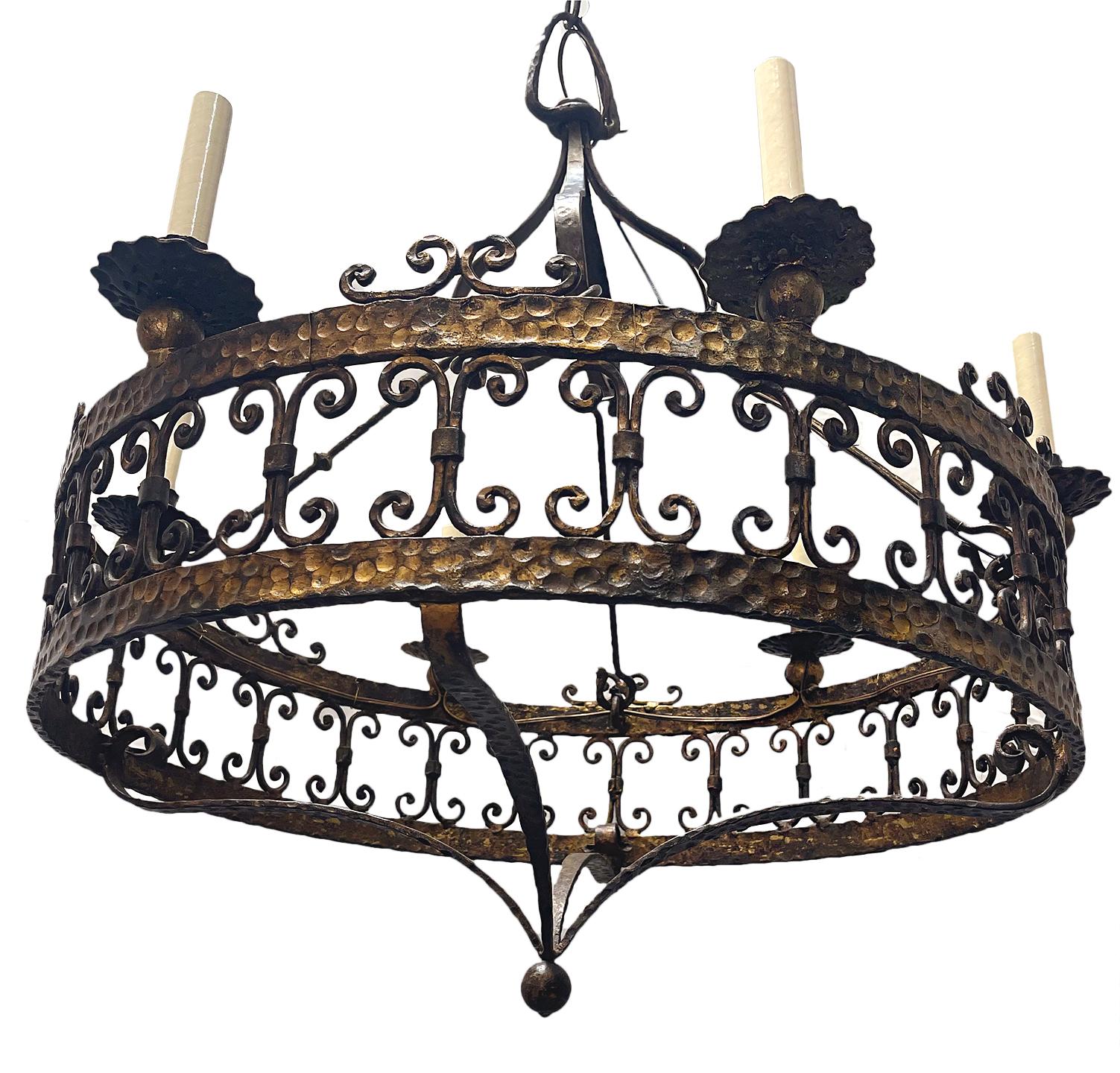 A French circa 1950's six-light gilt metal and hammered iron chandelier with original patina.

Measurements:
Height: 33