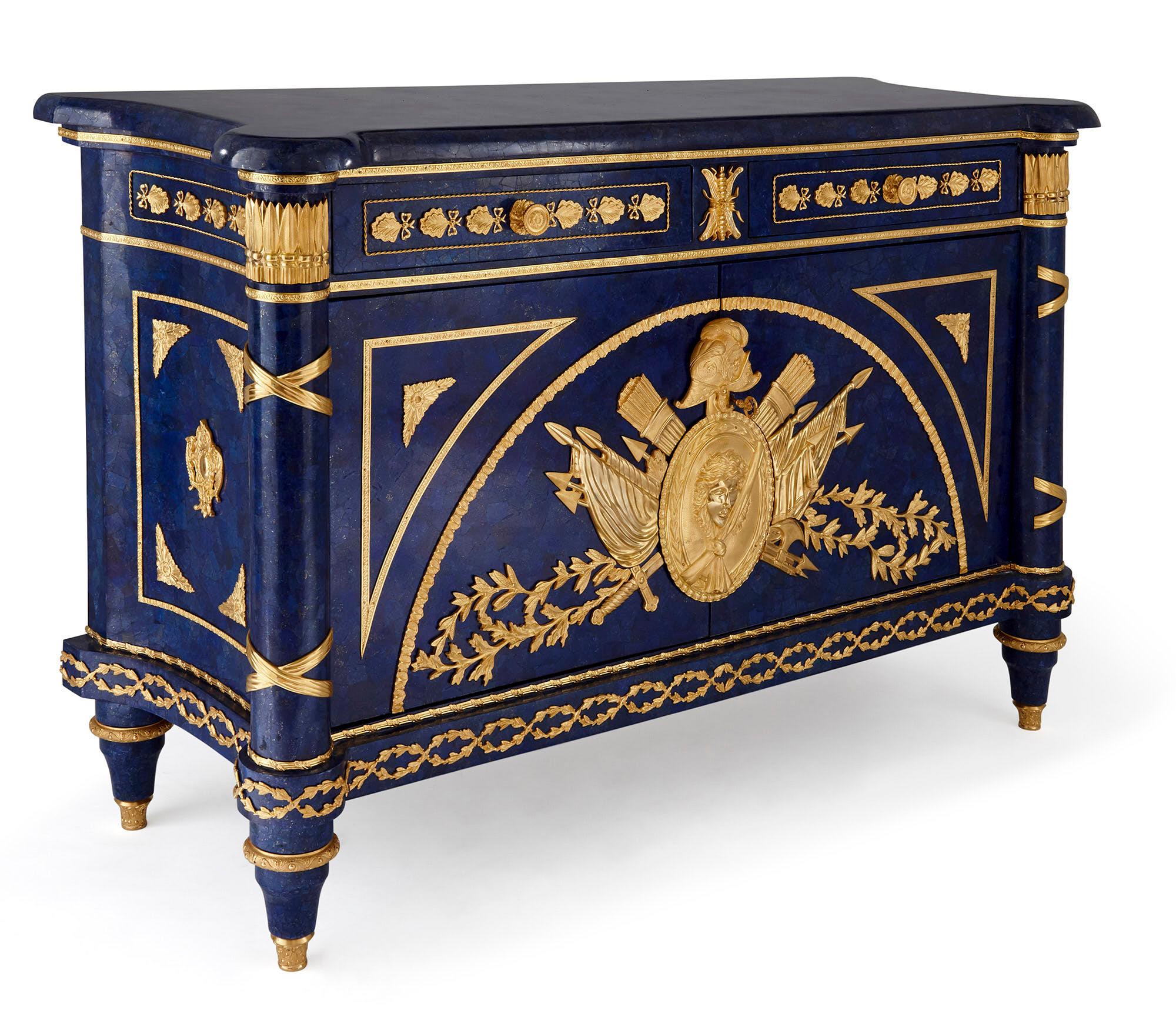 French gilt metal mounted lapis commode in the Empire style
French, 20th century
Size: Height 94cm, width 147cm, depth 55cm

Crafted in the Empire style, this beautiful commode is wrought from lapis and gilt metal, in a timeless combination of rich