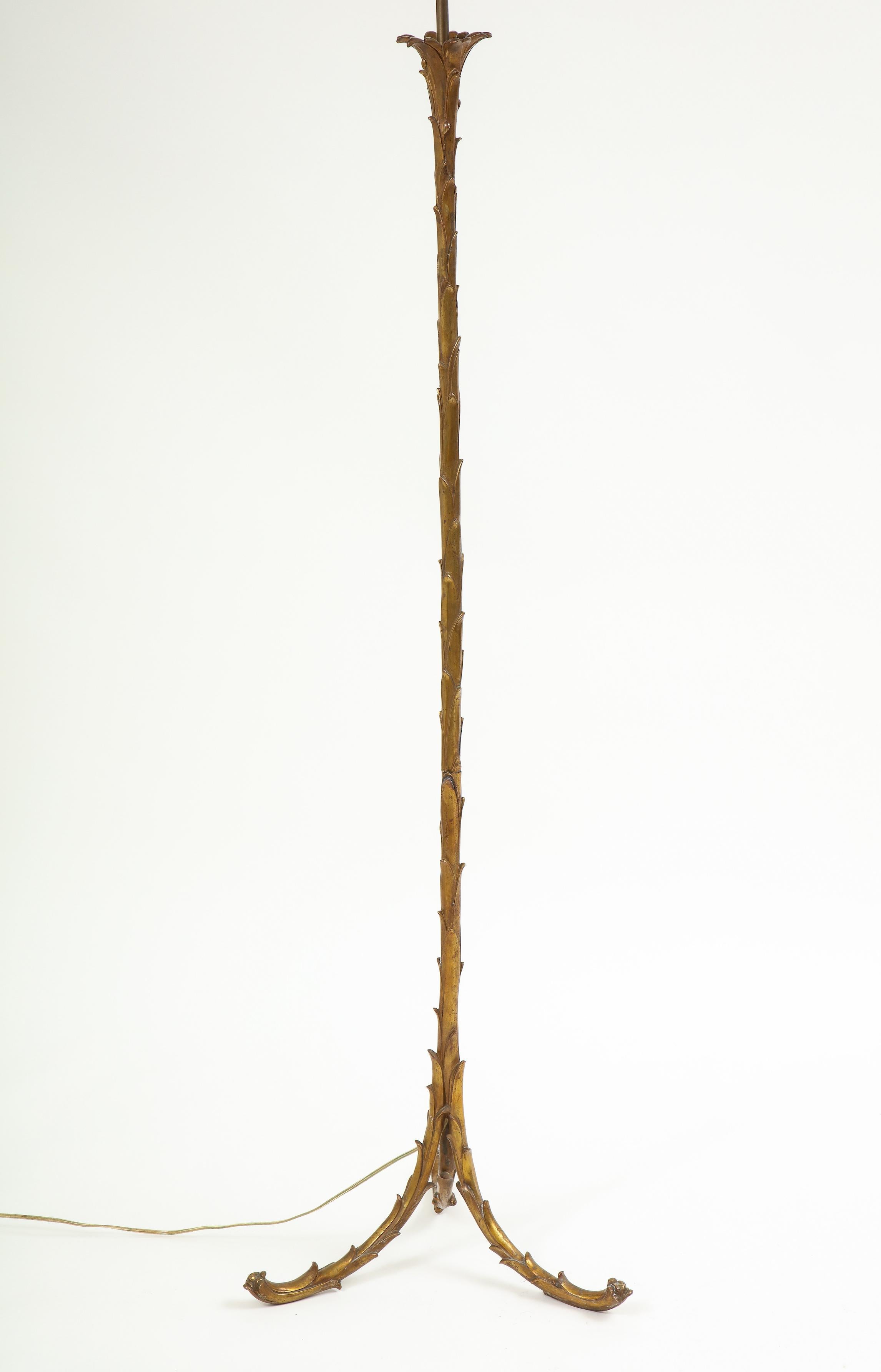 Elegantly proportioned. The slender columnar support with outward furling palm leaves at the top and supported on three out swept legs fitted with two light bulb sockets.