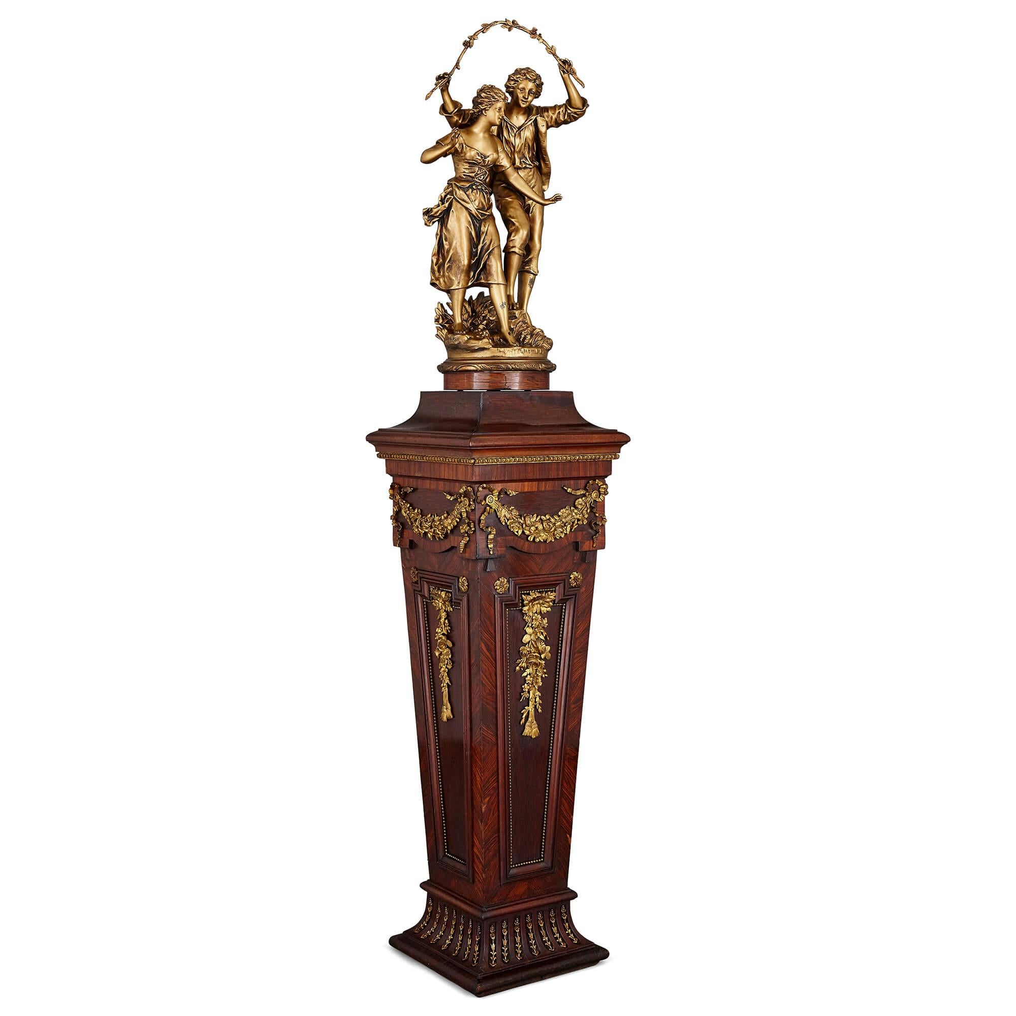 French gilt metal sculpture on Neoclassical pedestal by Ernest Rancoulet
French, early 20th century
Measures: Height 165cm, width 34cm, depth 34cm

This fine sculpture group is by the French artist Ernest Rancoulet, who lived from 1870 until