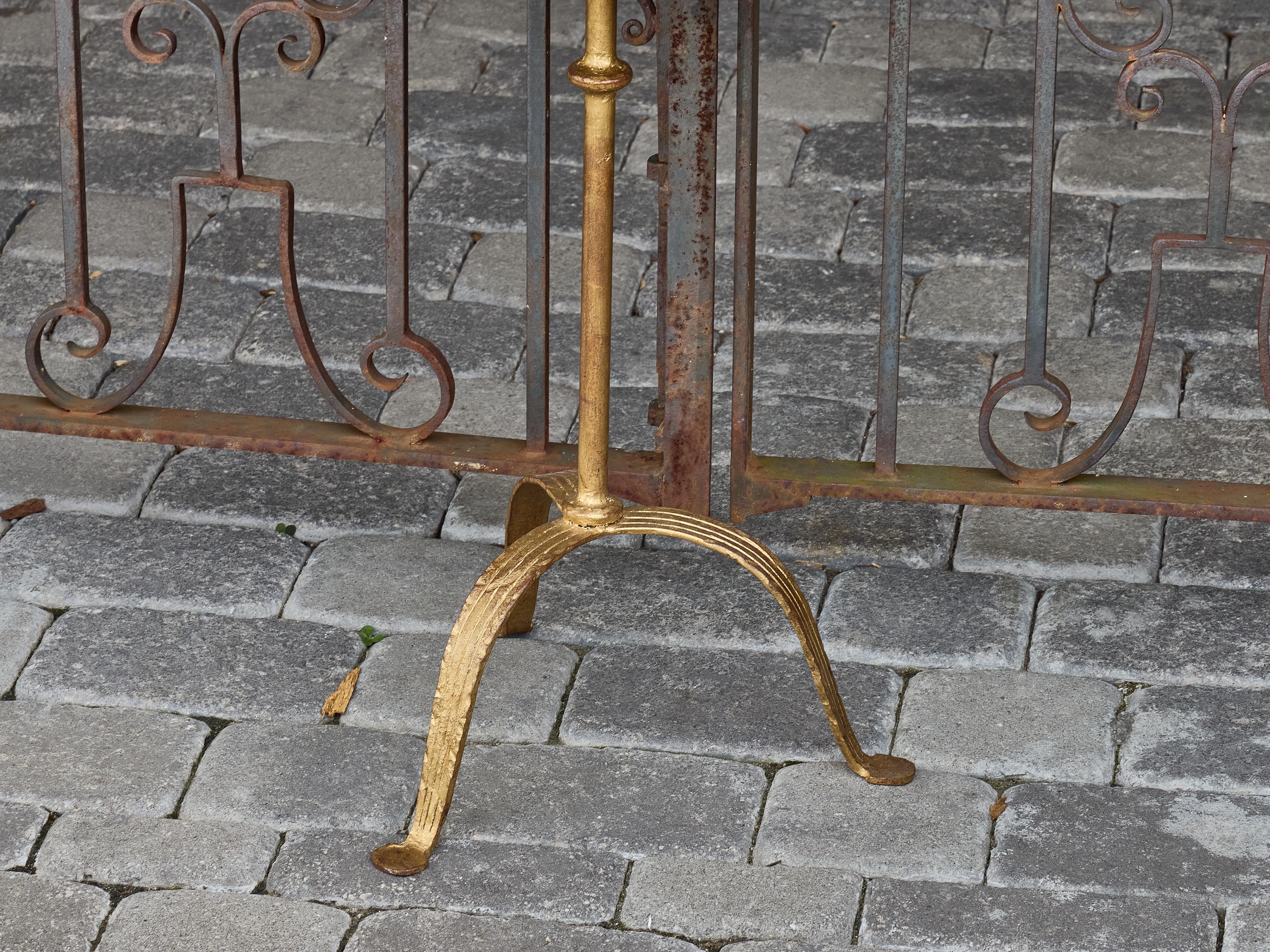Charmante table d'appoint en métal doré datant d'environ 1920, cette petite pièce offre à la fois un attrait décoratif et une polyvalence pratique. Le plateau rond est doté d'un insert en verre miroir épuré encadré d'une bordure en corde torsadée -