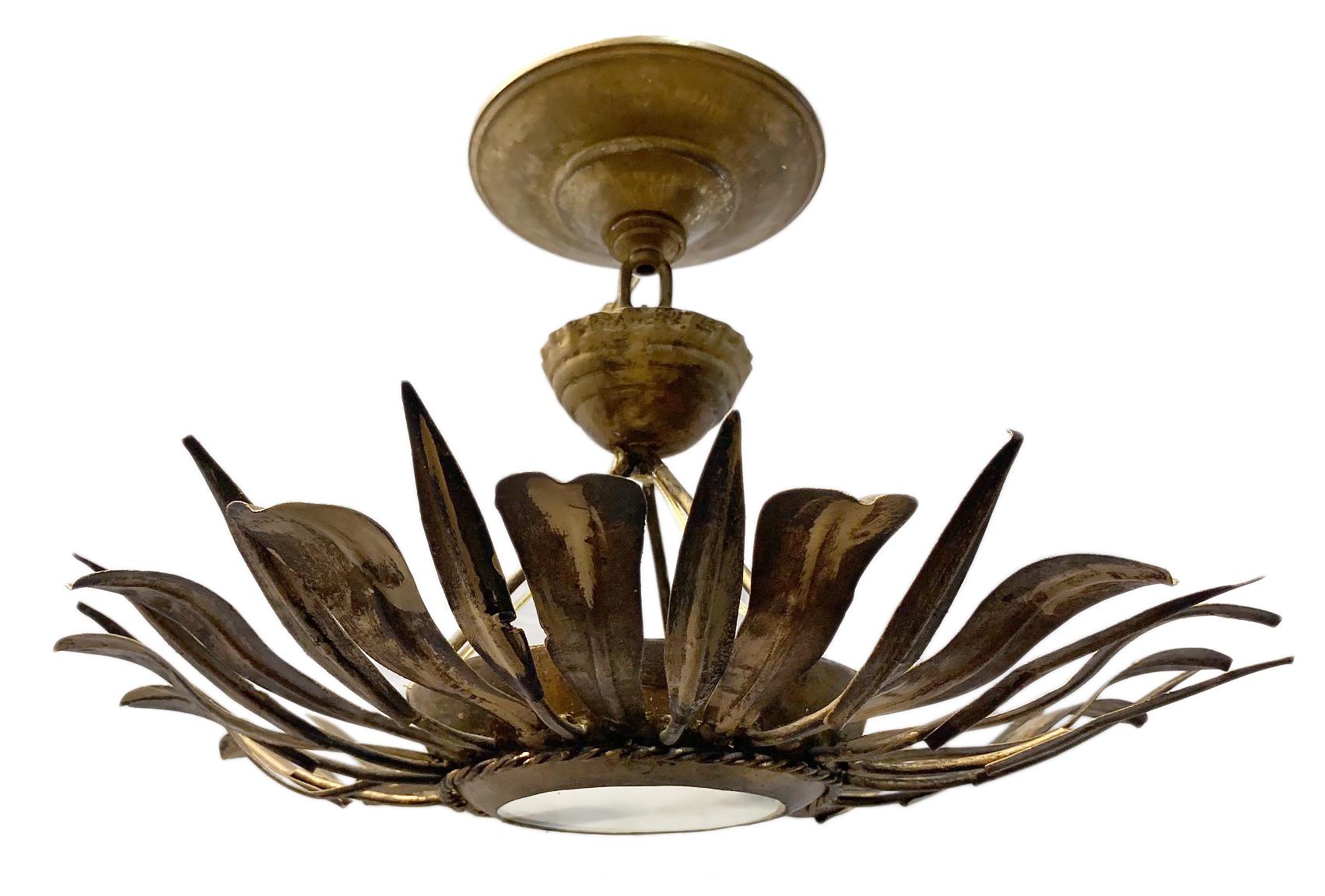A French circa 1960s hammered and gilt metal light fixture with three lights and frosted glass inset.

Measurements:
Height 8